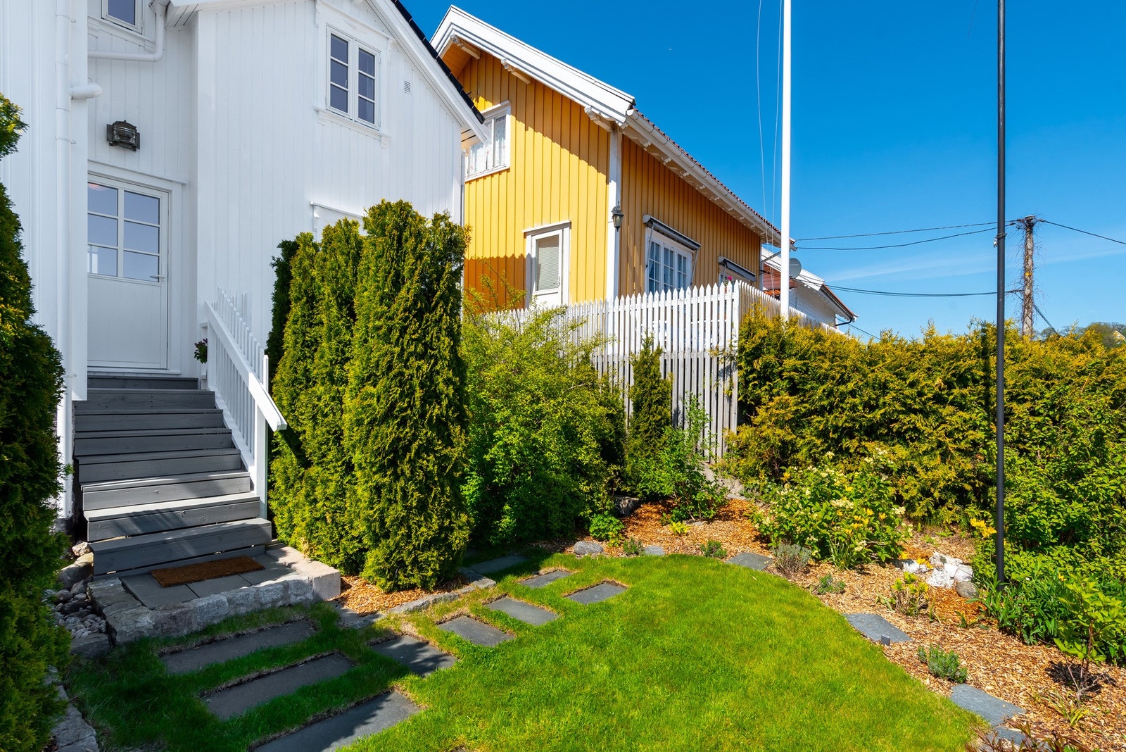 Koselig hage med beplanting, plen areal og her inngang til boligen fra hagen. Galleribilde