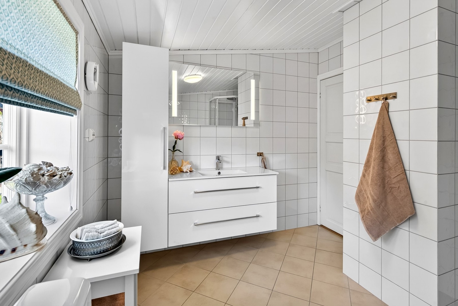 Bad med vegghengt servantinnredning og speil med integrert lys. Galleribilde