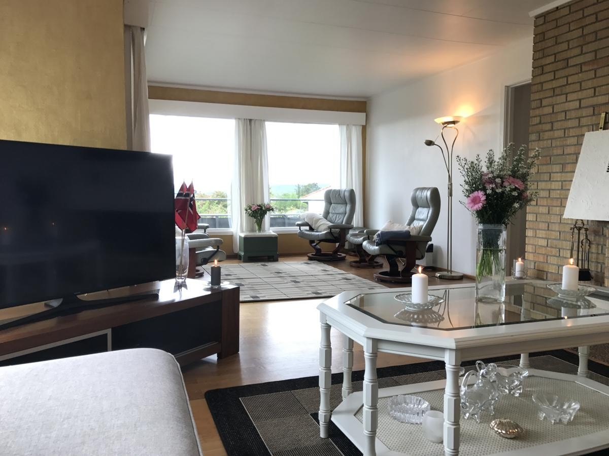 tatt fra sofaen i stuen. Store vinduer i hele stuen. Galleribilde
