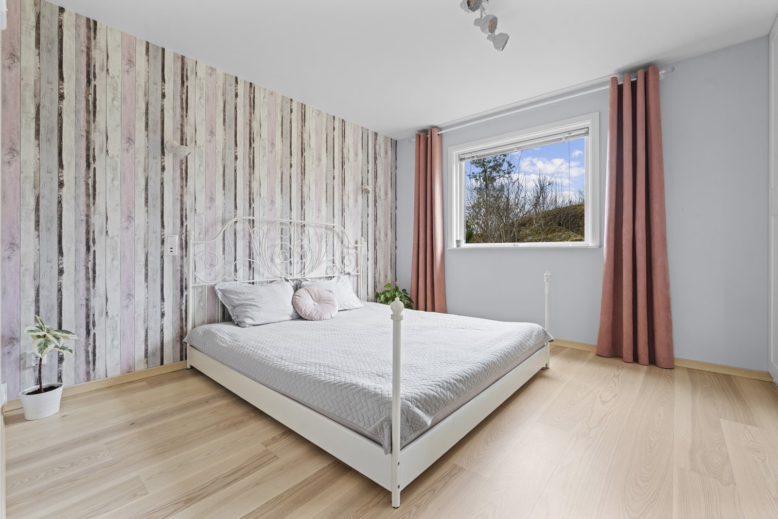 Boligens hovedsoverom har behagelig fargevalg på veggflaten med stor vindusflate. Galleribilde
