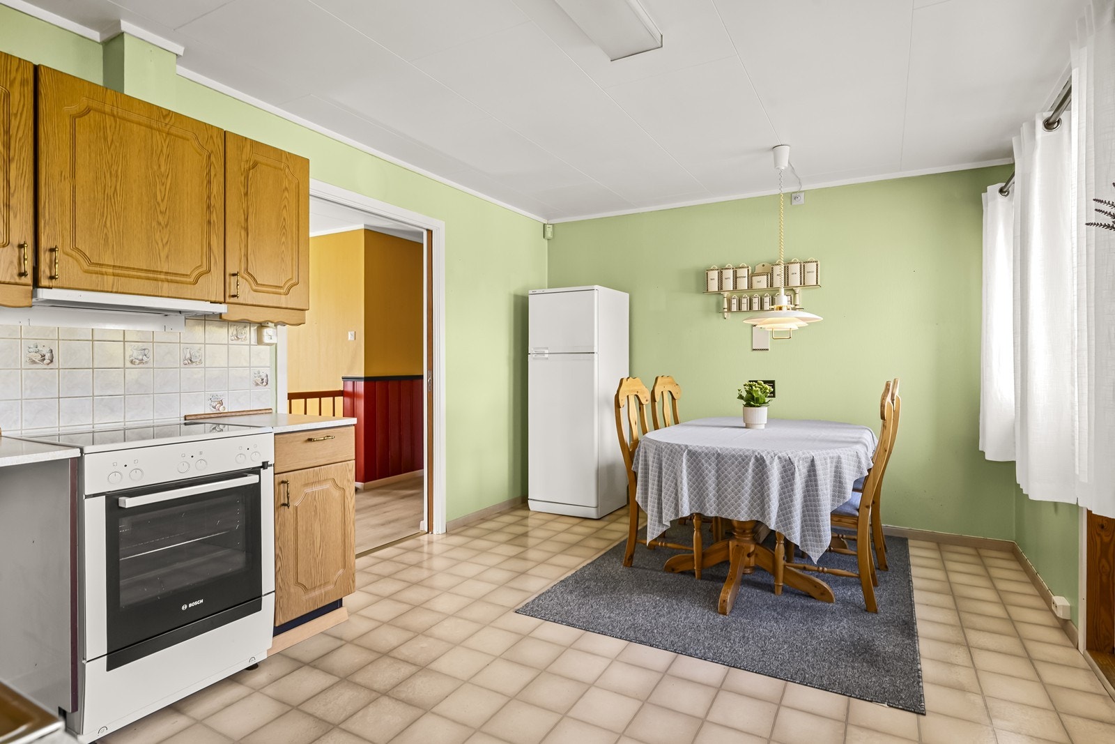 Kjøkkenet er utstyrt med frittstående komfyr, oppvaskmaskin og kjøl-/fryseskap. Galleribilde