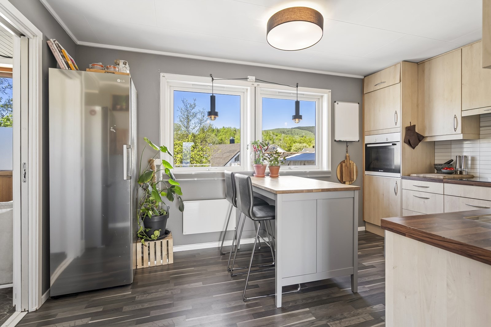 Kjøkkeninnredningen har laminerte fronter, laminert benkeplate og kitchenboard på veggen mellom benk og overskap. Galleribilde