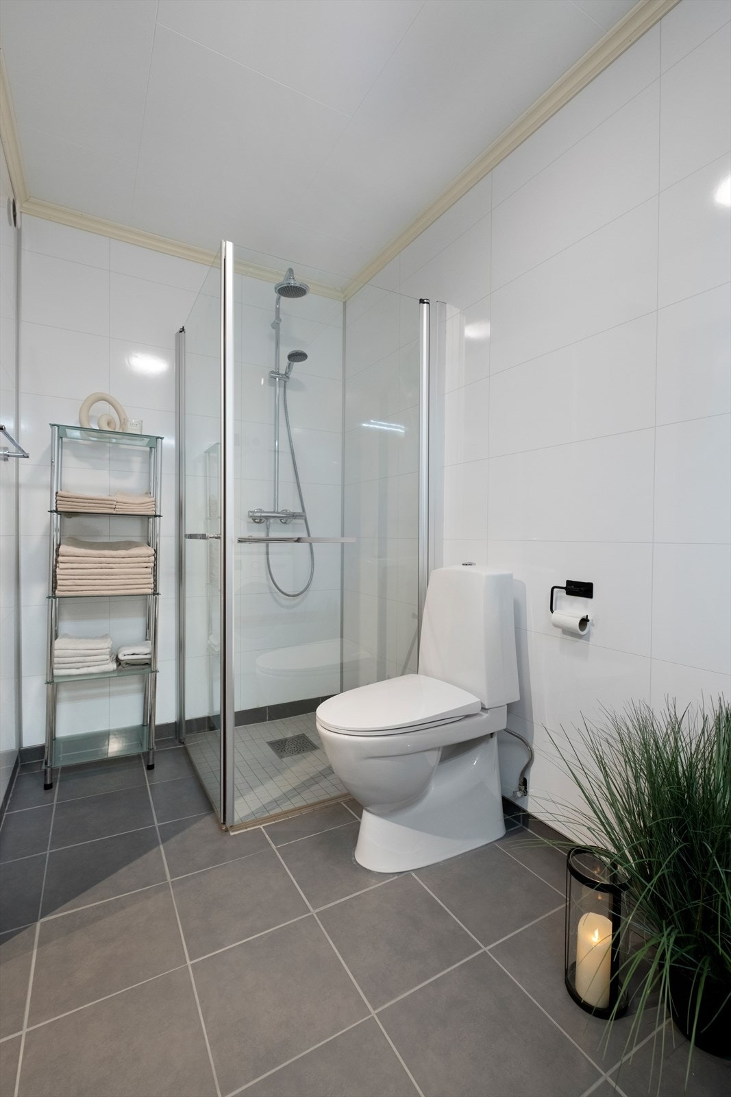 Badet er romslig og består av innredning med nedfelt servant, toalett, dusjvegger av glass og opplegg for vaskemaskin Galleribilde