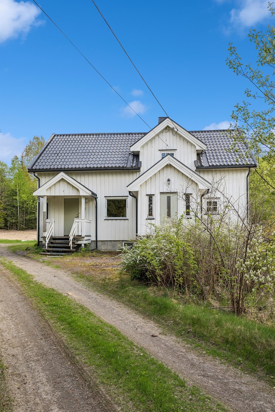 Våningshuset har tømmermannspanel og tak tekket med lakkerte, taksteinsformede stålplater. Galleribilde