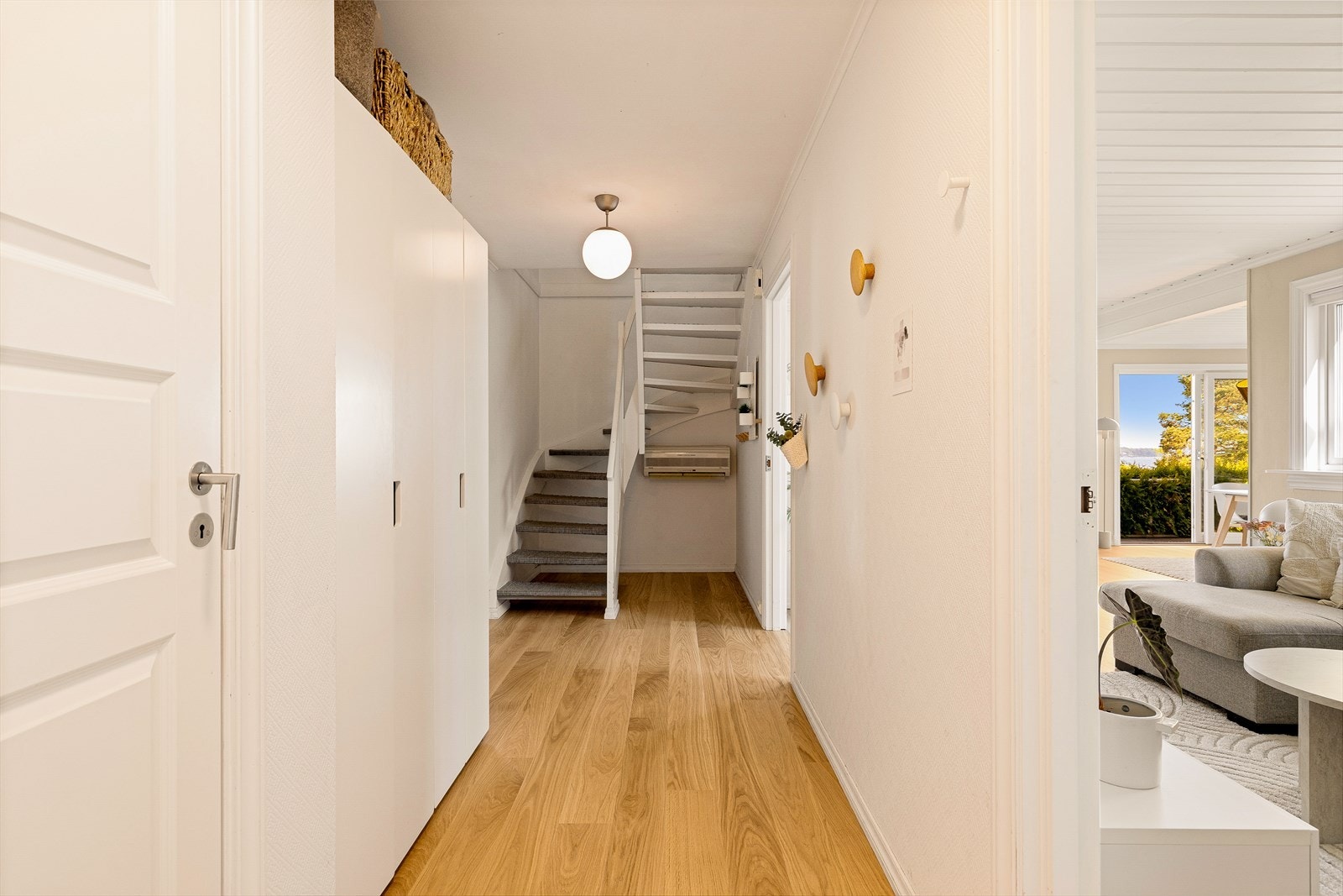 Gangen har plass til oppbevaring og en malt tretrapp med teppe på trinnene som leder opp til andre etasje. Galleribilde