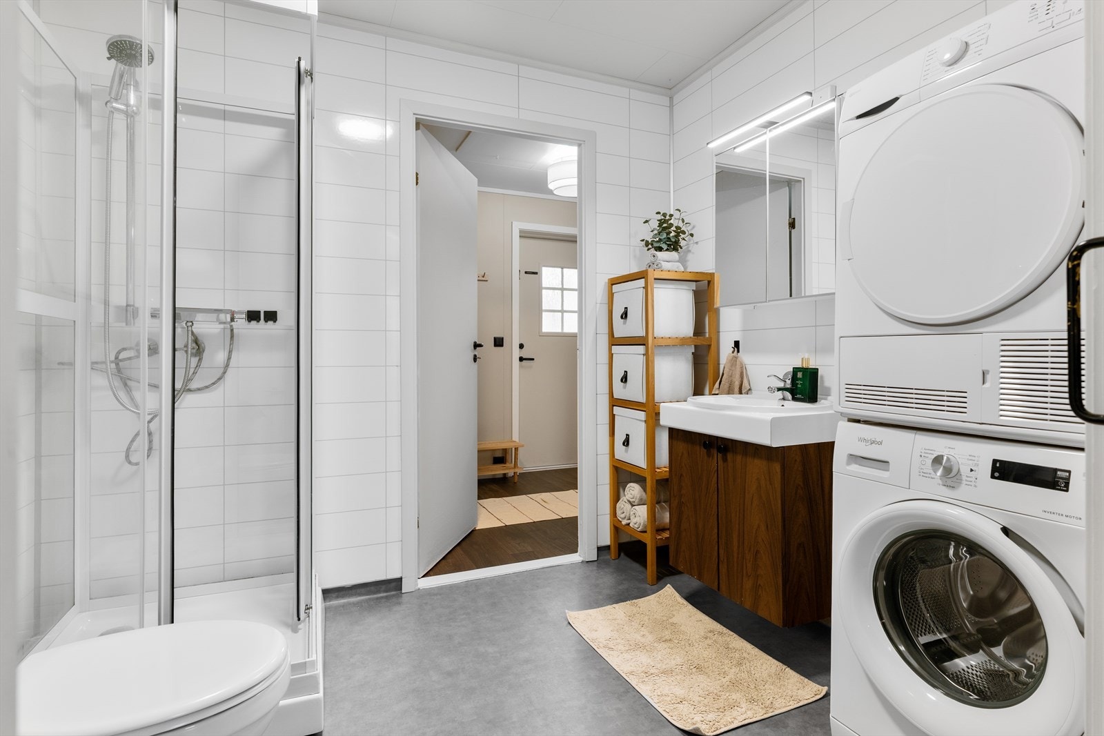 Badet er utstyrt med dusjkabinett, servant med speil, wc samt opplegg for vaskemaskin og tørketrommel. Galleribilde