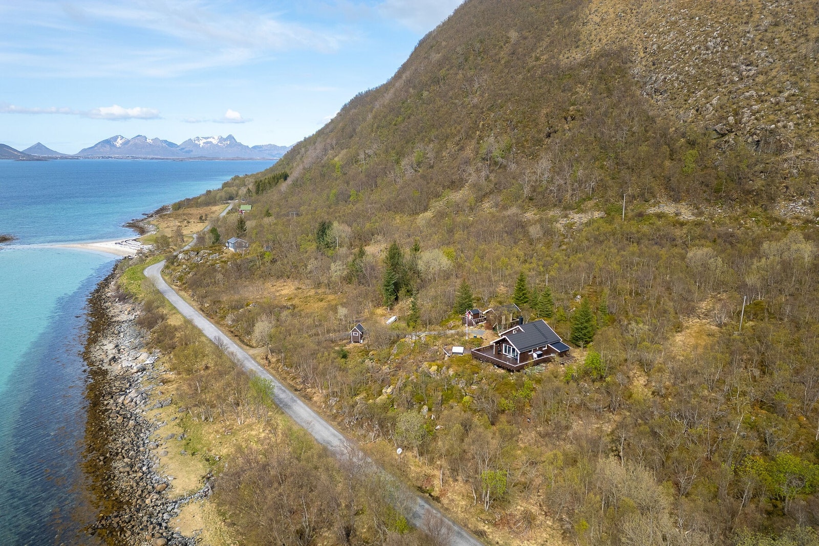 Eiendommen ligger usjenert til i et fjellpreget terreng med fylkesveien og sjøen like nedenfor. Galleribilde