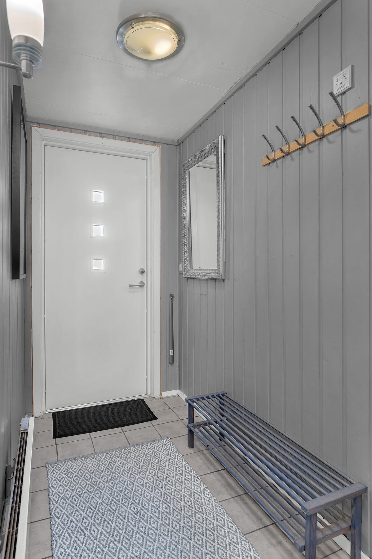 Entré med flislagt gulv og plass til å henge fra seg yttertøy. Galleribilde