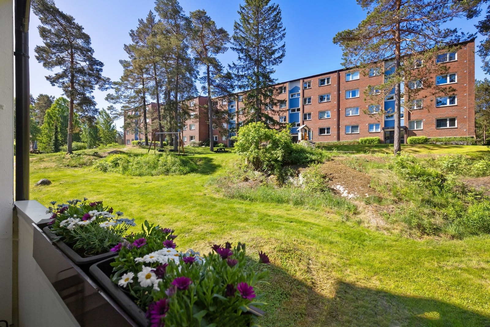Det er flotte felleområder mellom bebyggelsen. Balkongen har også integrerte blomsterkasser. Galleribilde