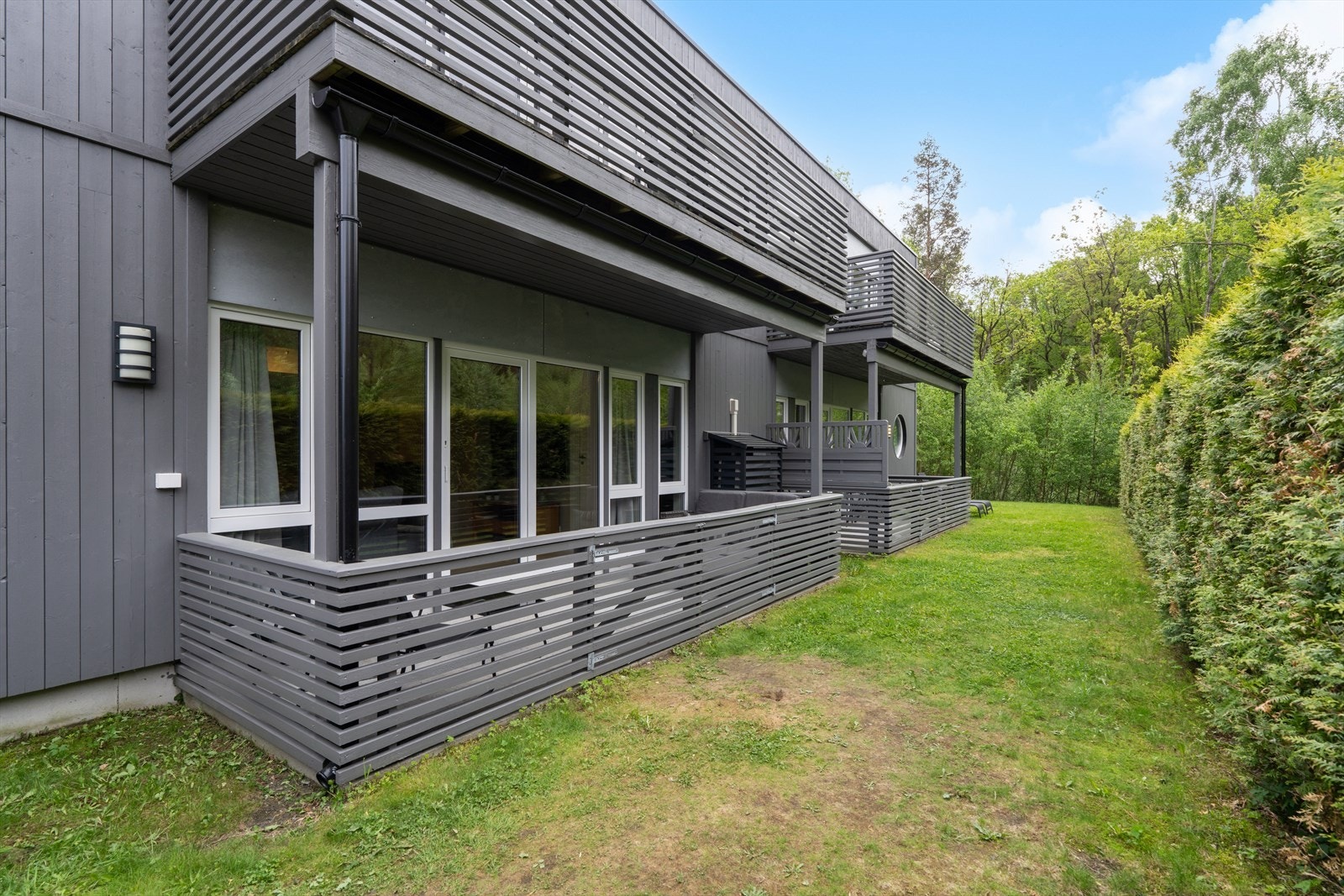 Uteplassen er skjermet av hekk og har en tilhørende gressplen. Galleribilde