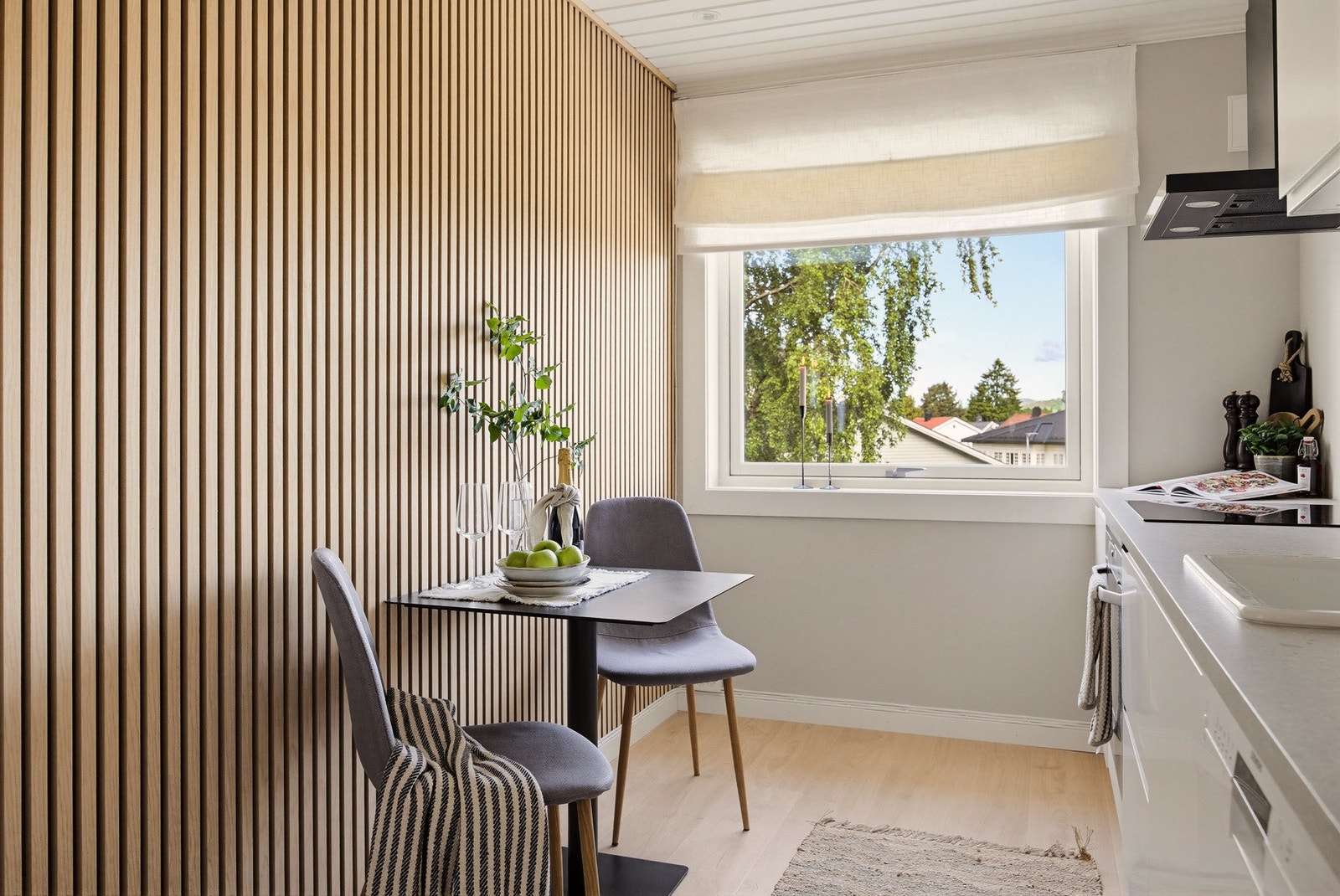Langs den ene veggen gir dekorative spiler kjøkkenet et særpreget og elegant uttrykk. Det er også plass til et hyggelig frokostbord på kjøkkenet. Galleribilde