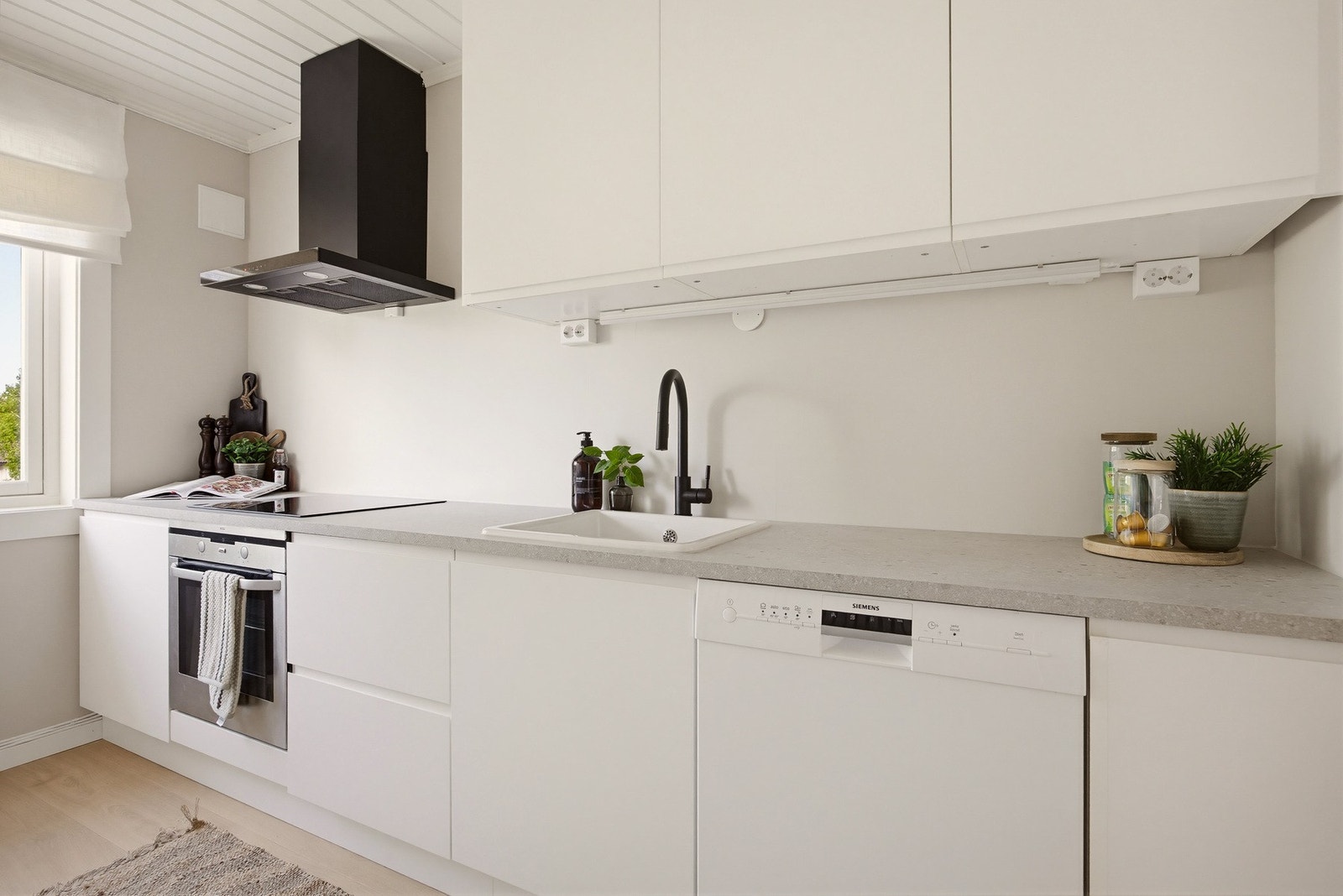 Innredningen er utstyrt med laminat benkeplate, nedfelt kum og veggmontert kullfilterventilator i stål. Induksjonstopp og stekeovn er helt nye fra 2026, og er integrert i innredningen. Galleribilde