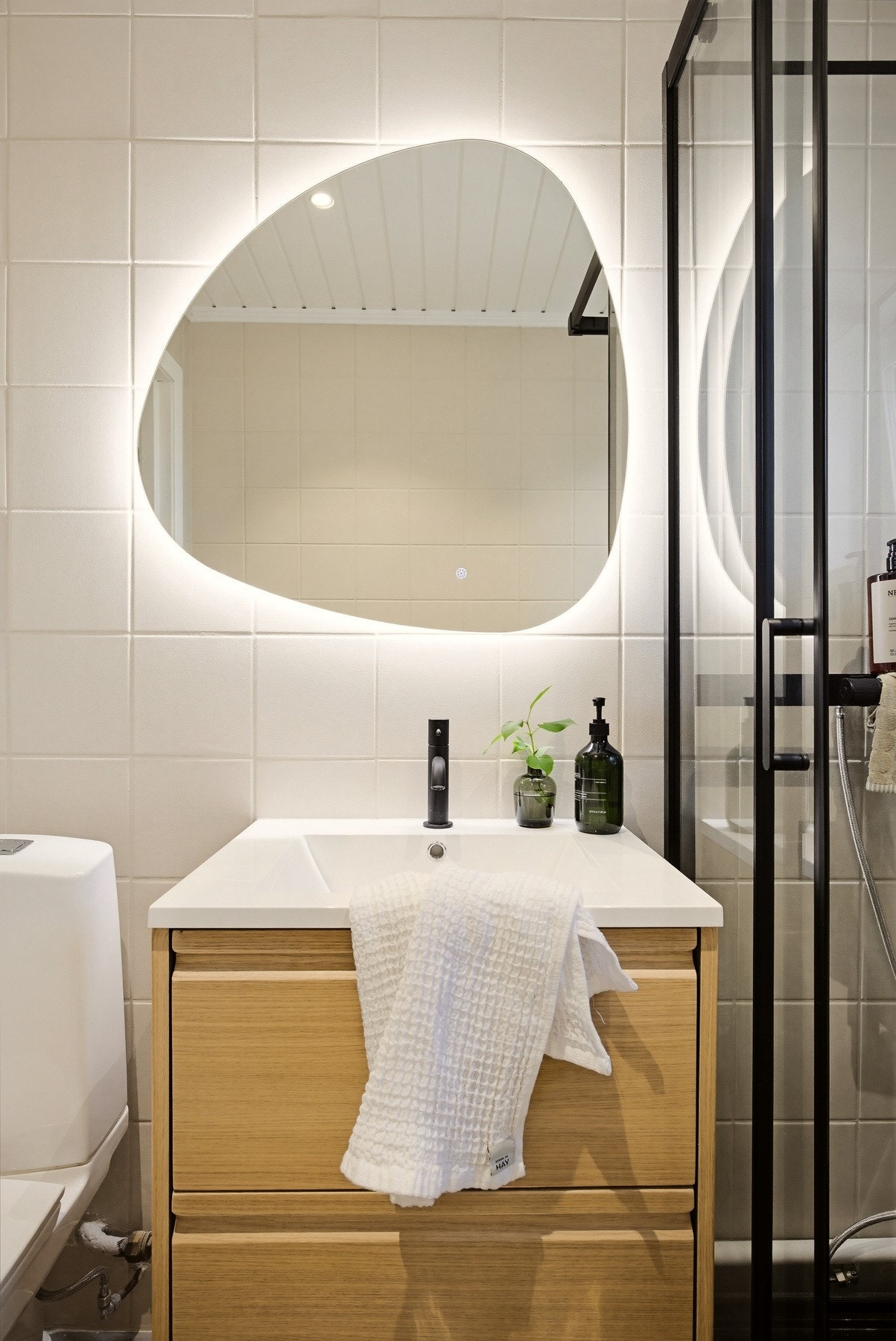 Badet har et lyst og tidløst uttrykk med lyse fliser på både gulv og vegger. Gulvvarme sørger for ekstra komfort, mens spotter i himlingen gir god belysning og en behagelig atmosfære. Galleribilde