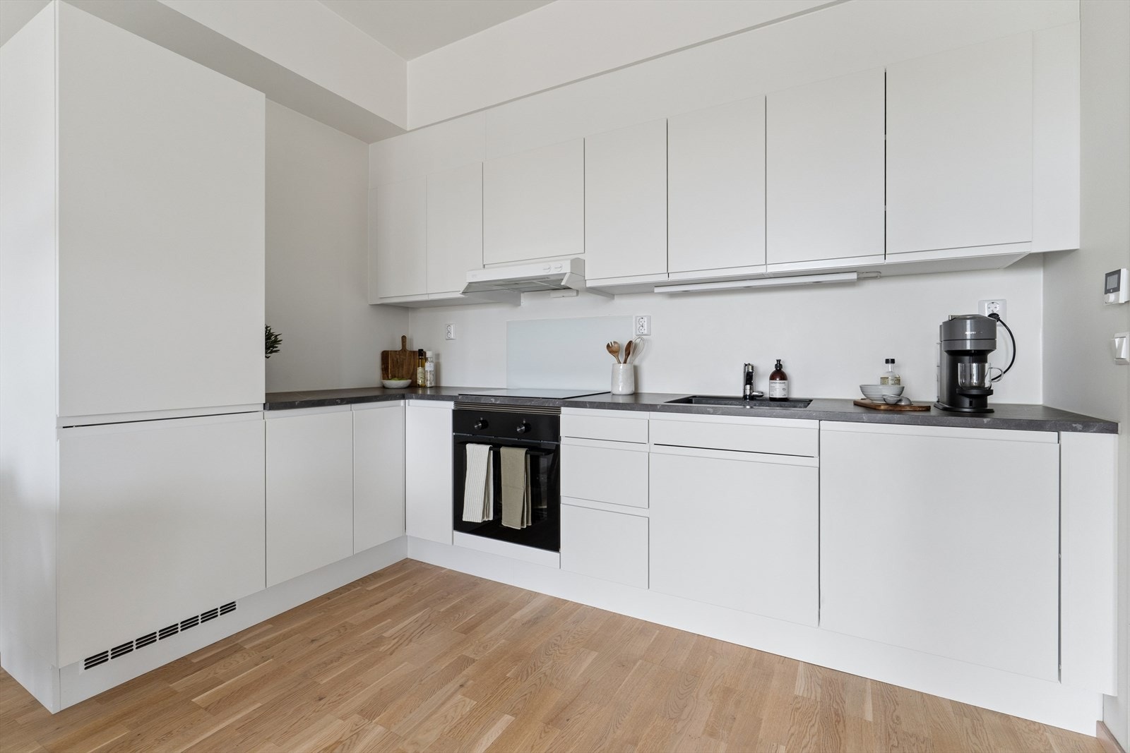Kjøkkeninnredning med glatte fronter og laminert benkeplate. Galleribilde