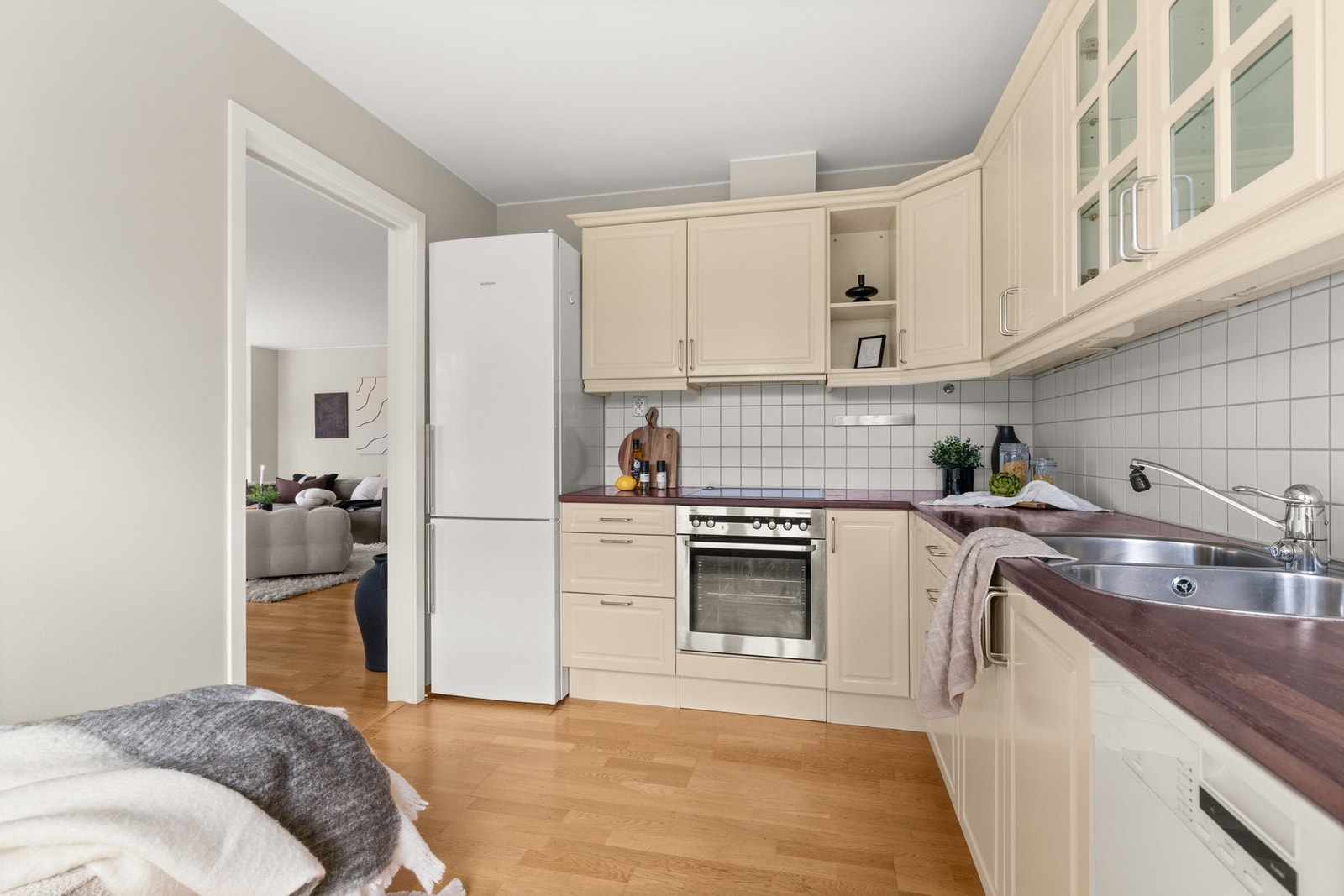 Kjøkkeninnredningen har lyse profilerte fronter, enkelte overskap med glassfronter og benkeplater i heltre. Galleribilde