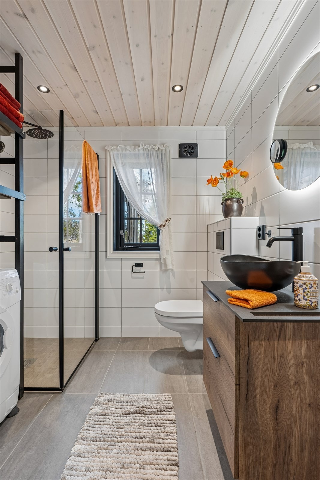 Badet er fra byggeåret 2023, med fliser på gulv og vegger. Her er det også opplegg for vaskemaskin. Galleribilde