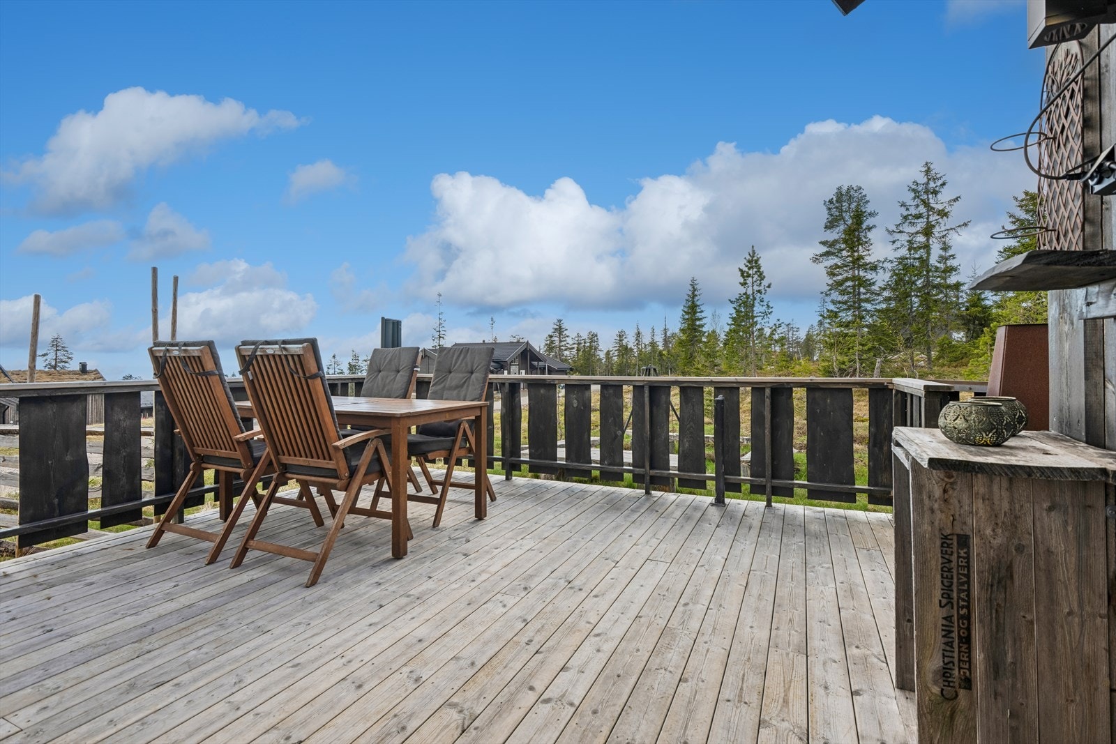 Stor åpen terrasse med god plass til utemøbler og med utsikt over det bølgende terrenget. Galleribilde