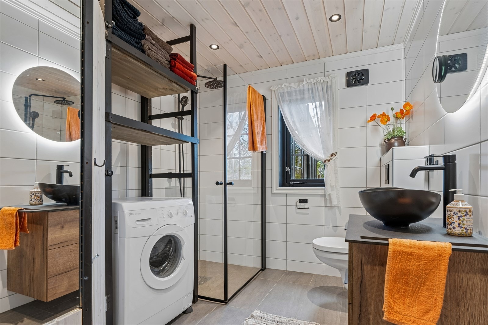 Badet er utstyrt med dusjhjørne med glassdører, vegghengt toalett og elektrisk avtrekksvifte. Galleribilde