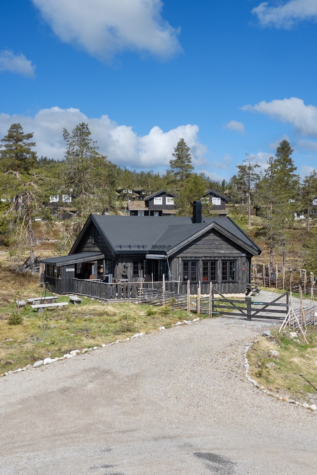 Gruset gårdsplass med adkomst til eiendommen og parkering. Galleribilde