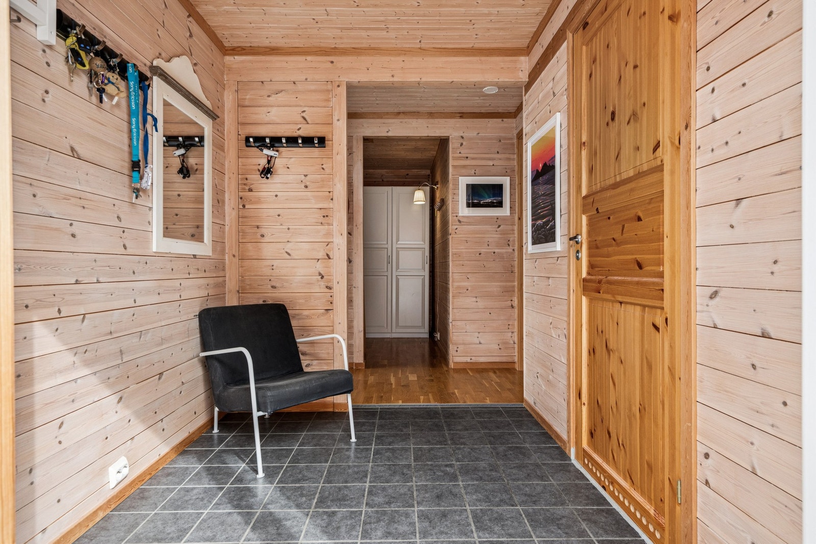 Entré med flislagt gulv. Vegger og himling har gjennomgående trepanel, som setter en lun stemning i boligen. Galleribilde