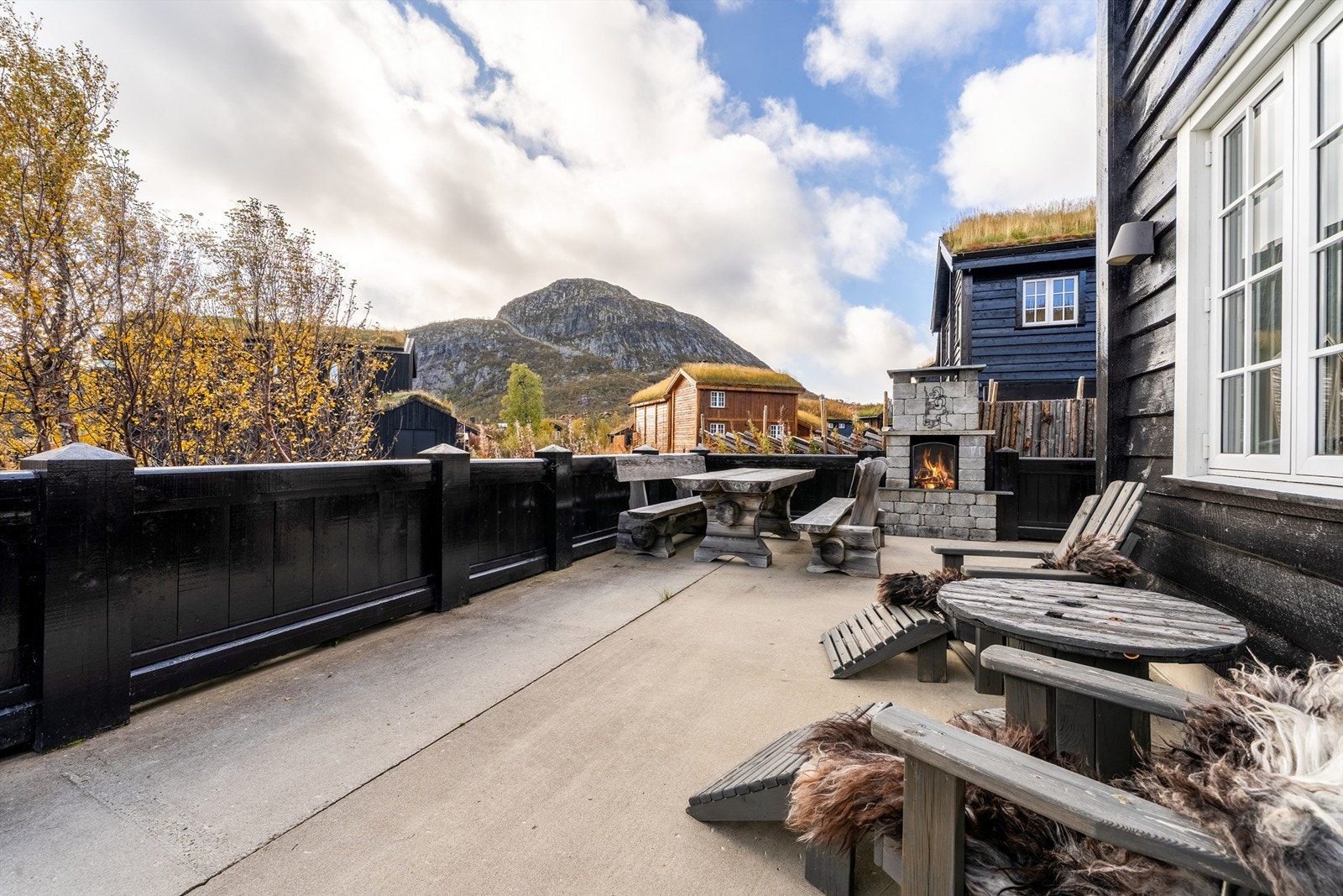 Stor flott støpt terrasse og murt utepeis. Galleribilde
