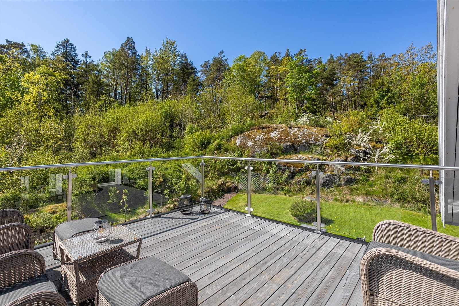 Balkongen på loftet har rekkverk i tre, glass og metall. Galleribilde