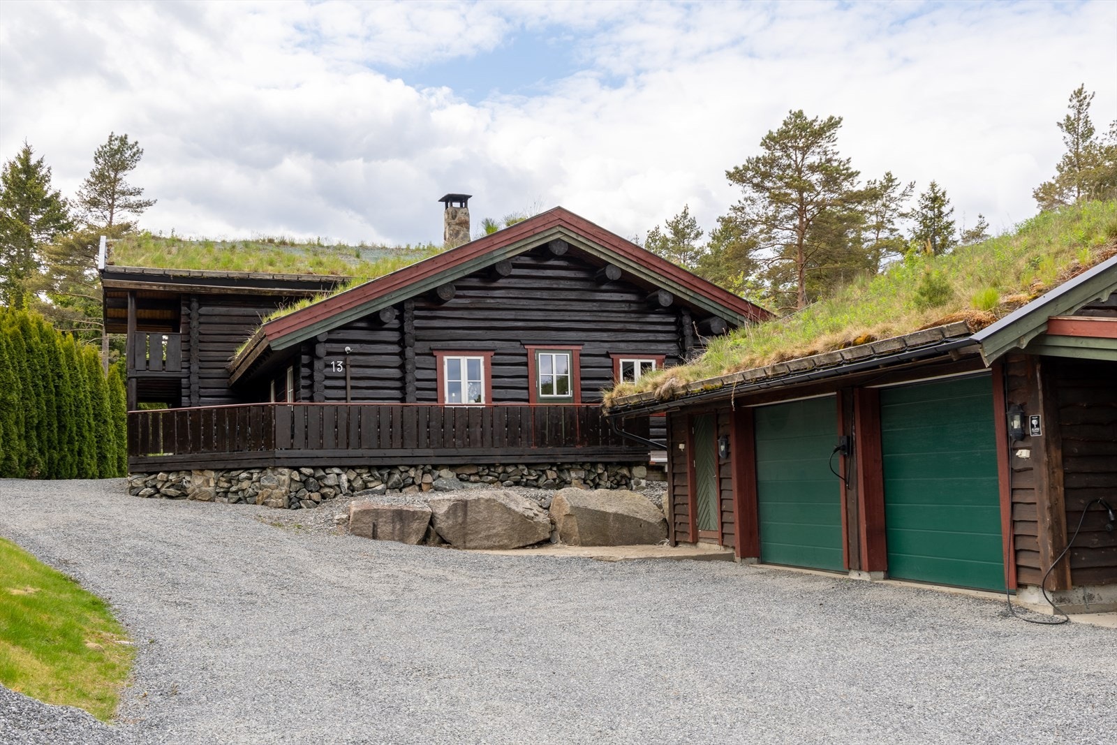 Garasjen er oppført med villmarkspanel, torvtekke og elektriske leddporter. Galleribilde