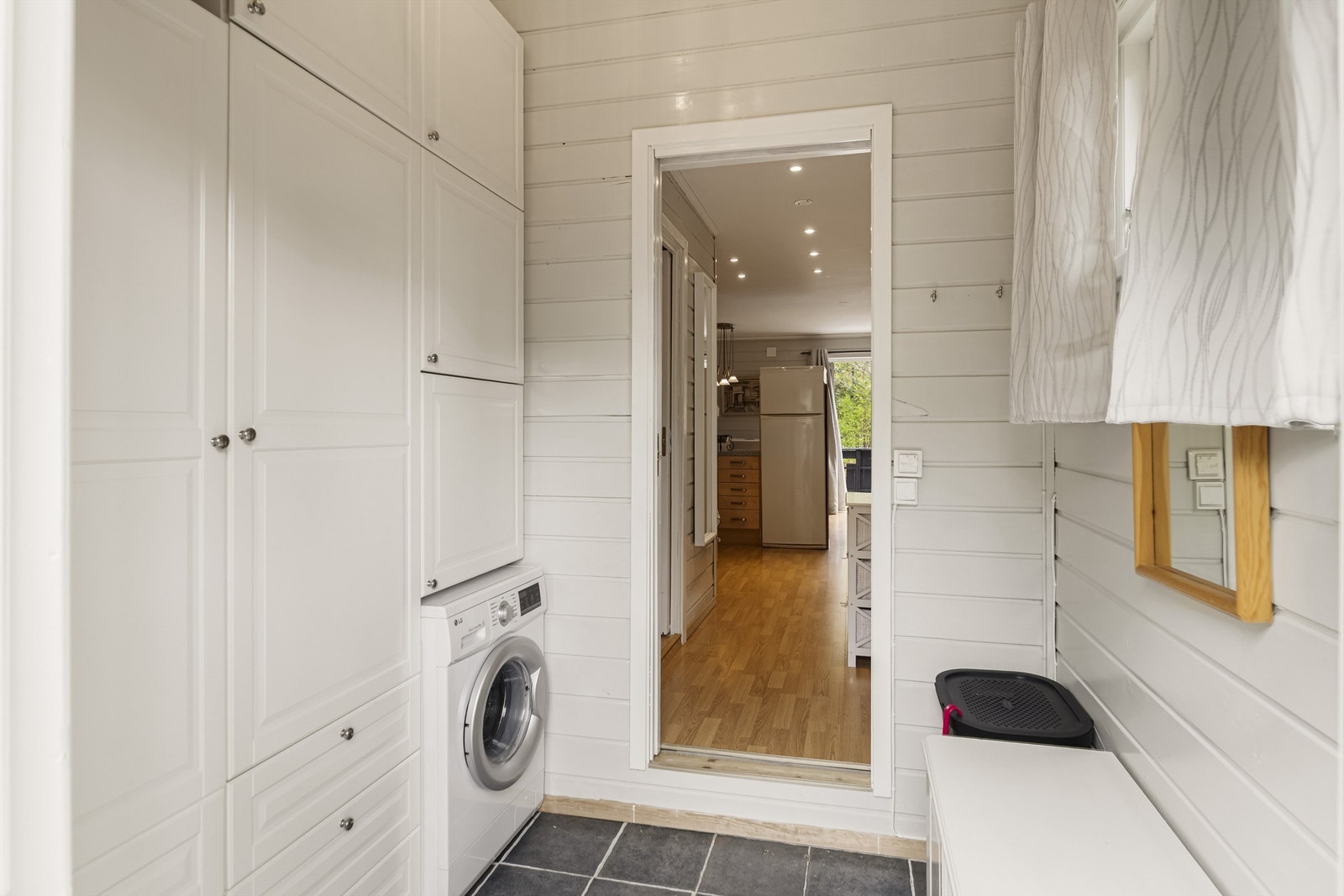 Praktisk entrè med mye skapplass og integrert vaskemaskin. Downlights med trinnløs dimming gir god belysning. Galleribilde