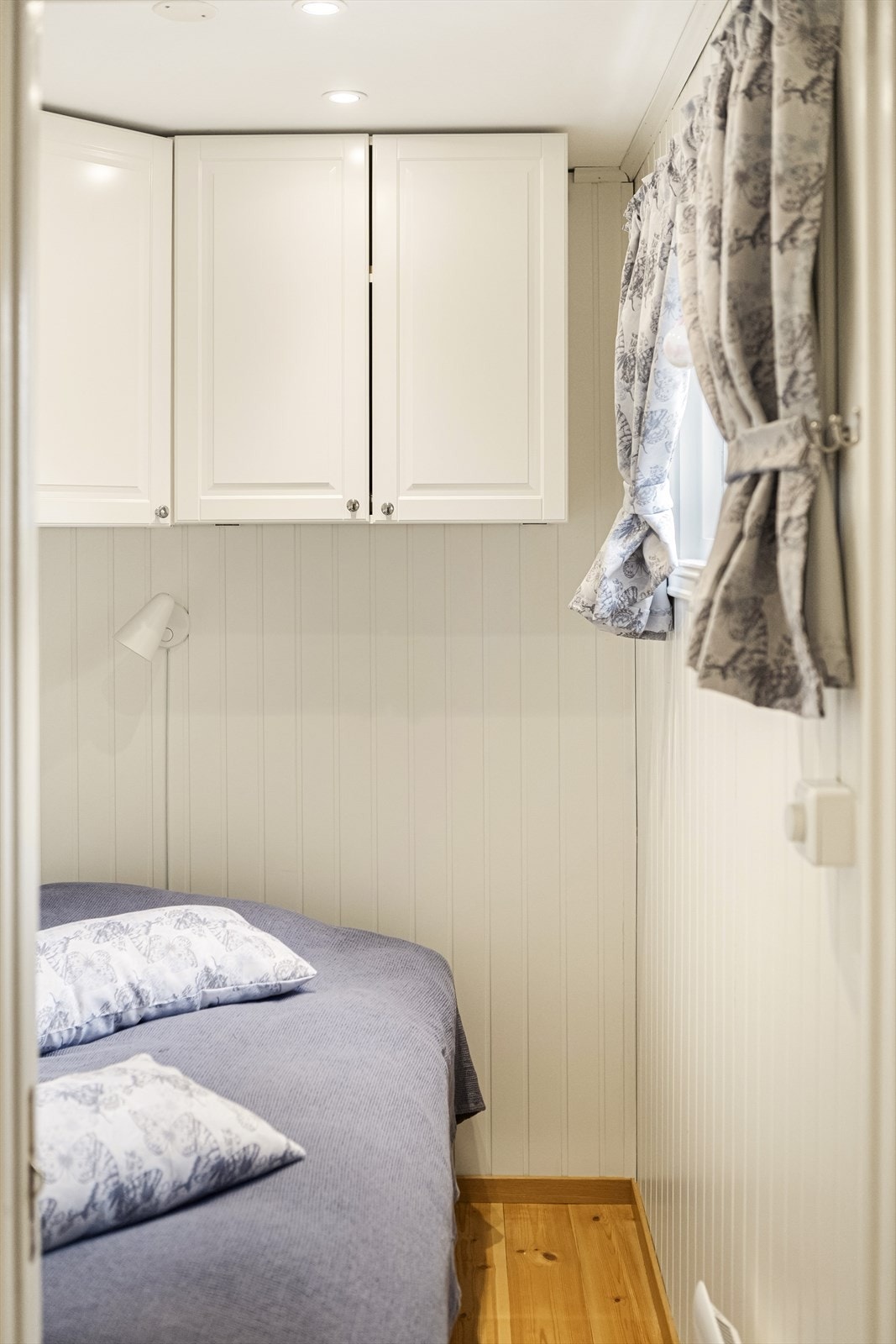 Rommet har innfelte downlights og malt trepanel på veggene. Galleribilde