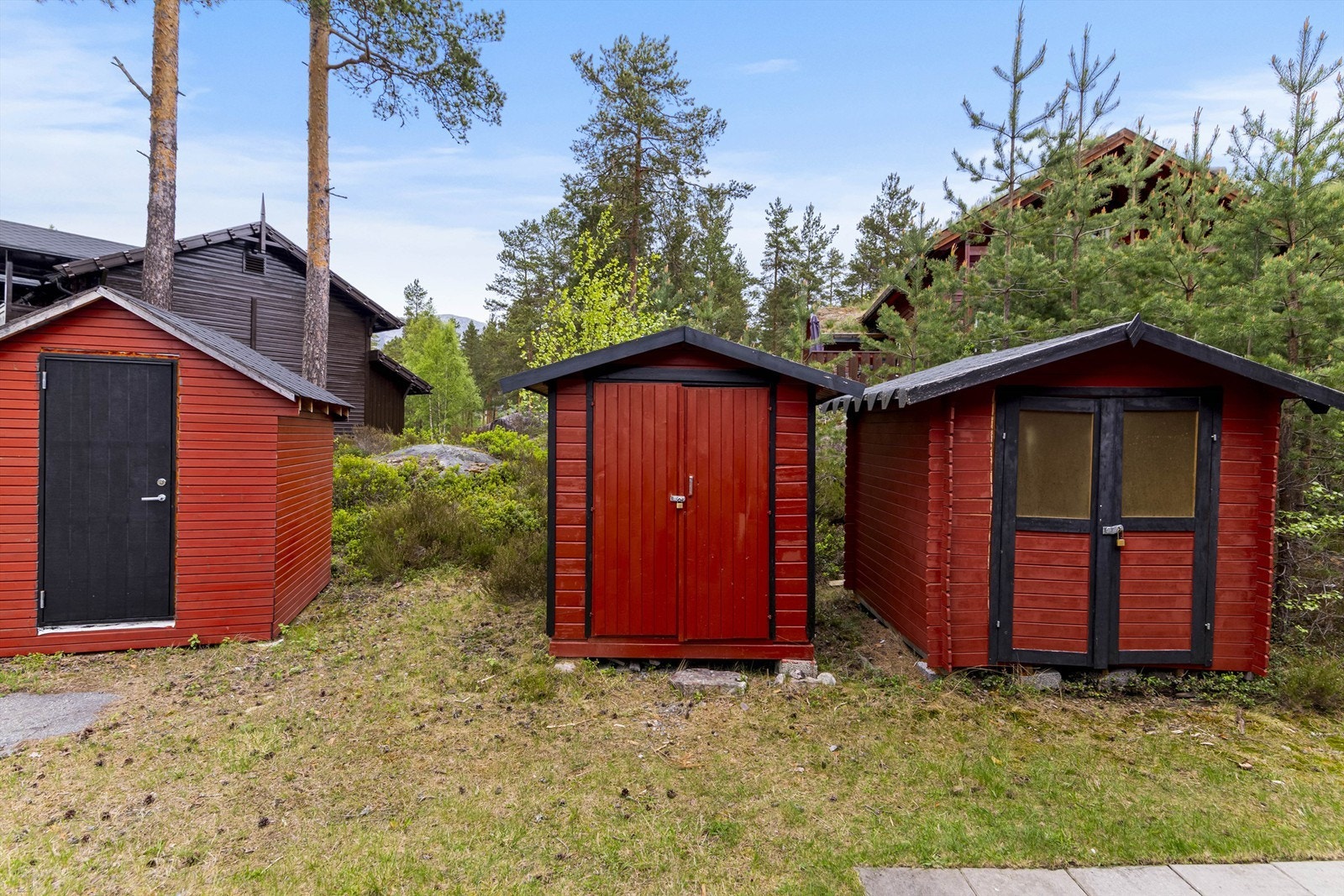 Det følger med en egen, frittstående bod for praktisk lagring av for eksempel ski- og turutstyr. Boden i midten av bildet følger leiligheten. Galleribilde
