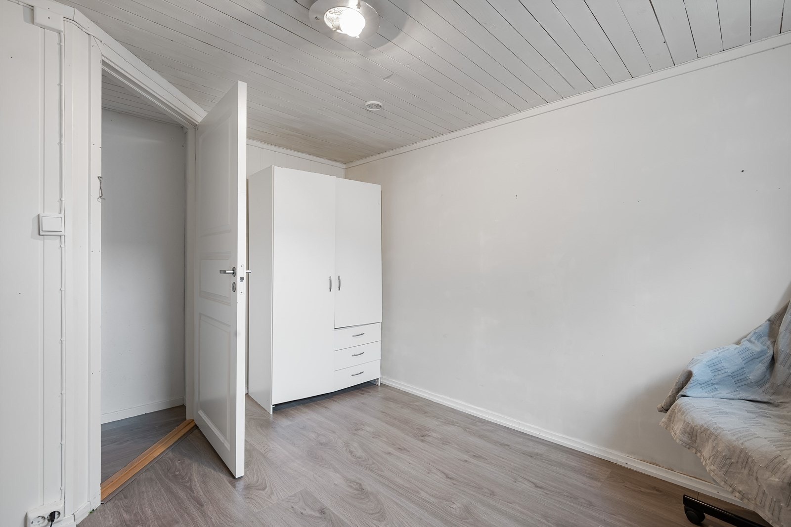 Rommet har moderne enstavs laminat fra 2022 på gulv og oppbevaringsplass i medfølgende garderobeskap. Det gjøres oppmerksom på at rommet ikke er godkjent for varig opphold. Galleribilde