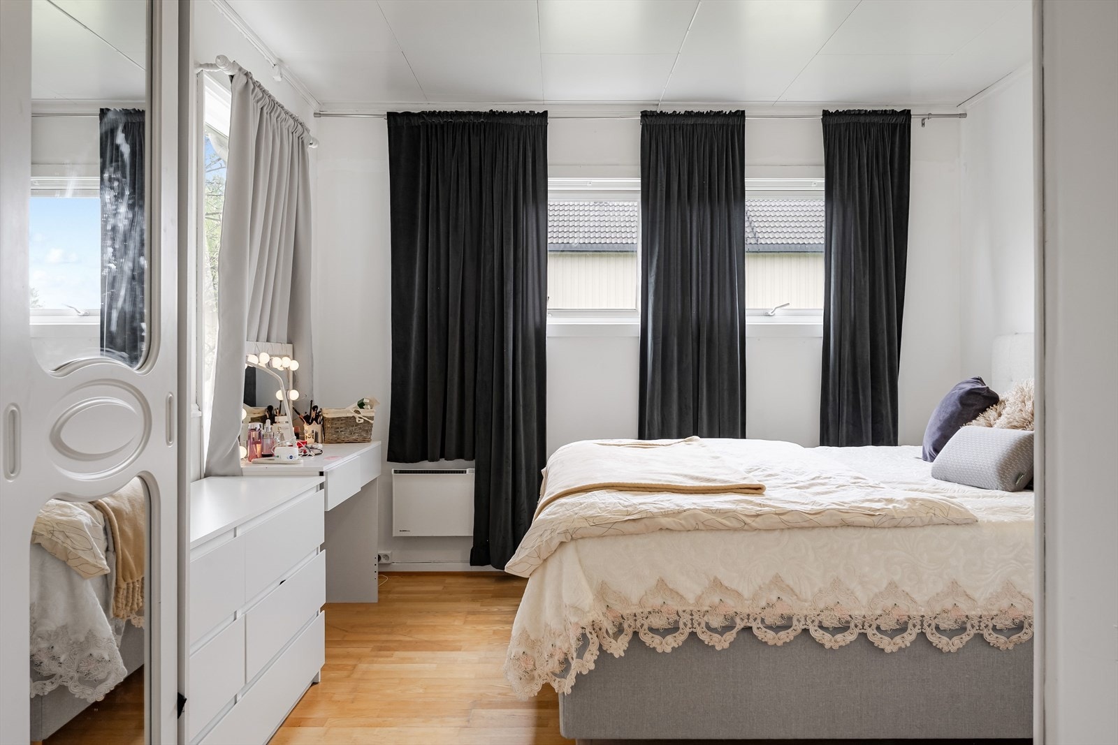 Soverom 1 er et lyst og romslig soverom med parkett på gulv og lysmalte overflater. Galleribilde