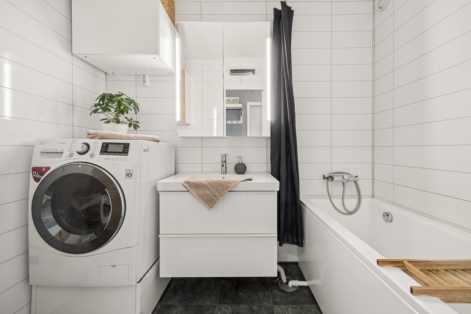 Badet er innredet med badekar og servant med underskap. Galleribilde