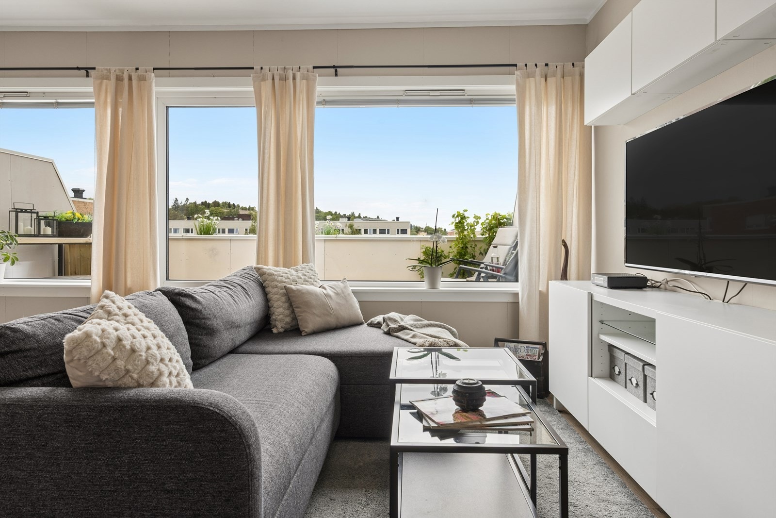 Store vindusflater i stuen slipper inn rikelig med dagslys. Galleribilde