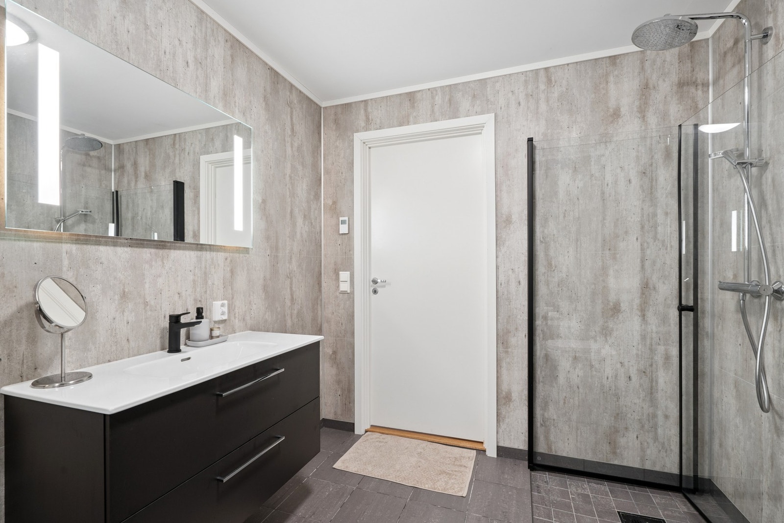 Romslig baderom på første plan, i samme stil som badet oppe. Også her har man, i likhet med store deler av boligen, oppvarming via vannbåren varme. Galleribilde
