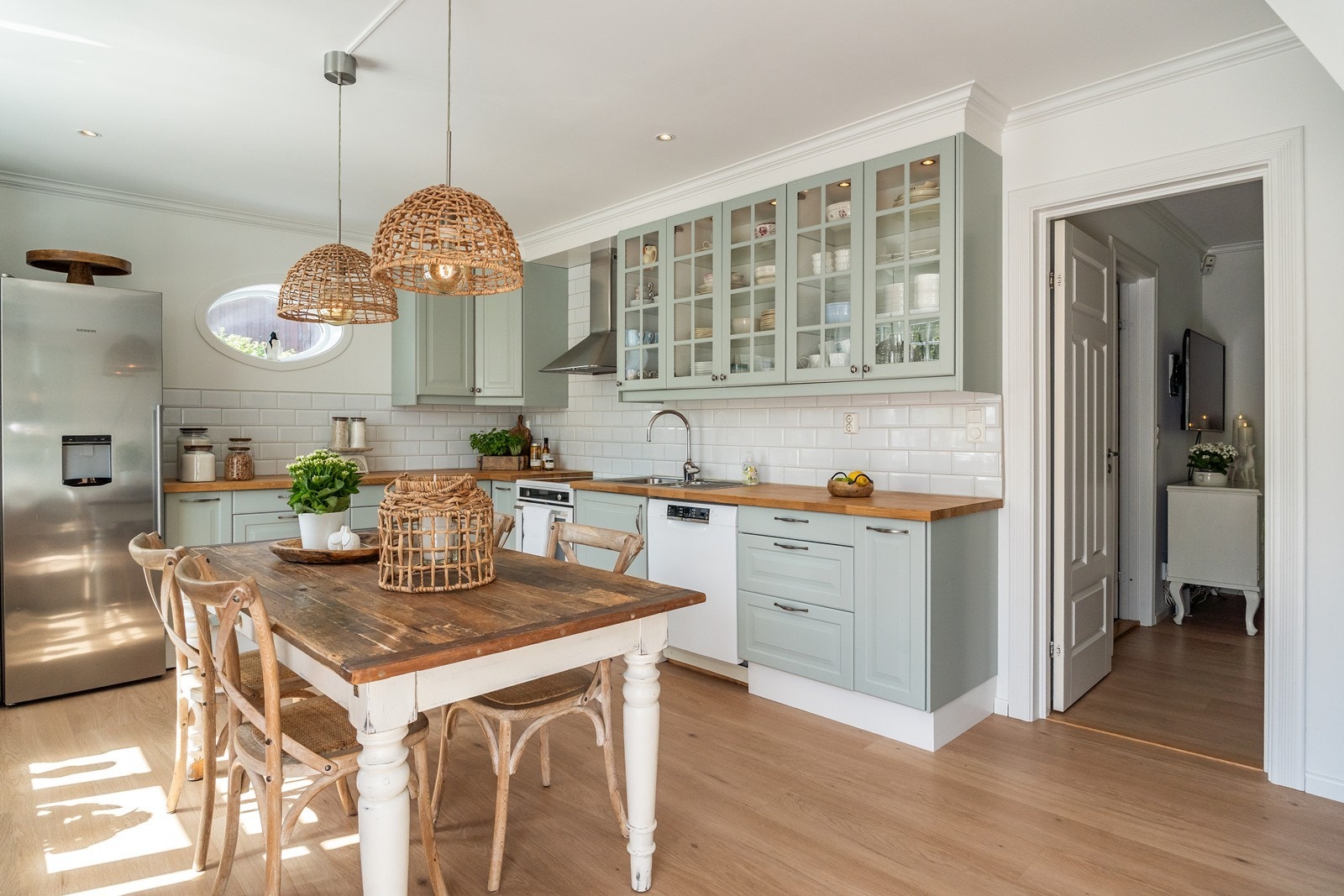 Elegant og lekkert kjøkken bestående av en klassisk innredning utført med profilerte fronter, noen overskap med glassfronter, i en nydelig og delikat grønntone. Galleribilde
