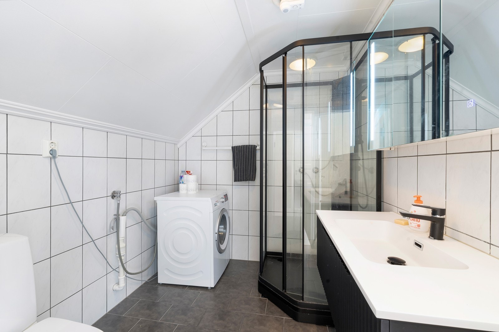 Flislagt bad med varmekabler, dusjkabinett, servant og toalett. Opplegg til vaskemaskin. Galleribilde