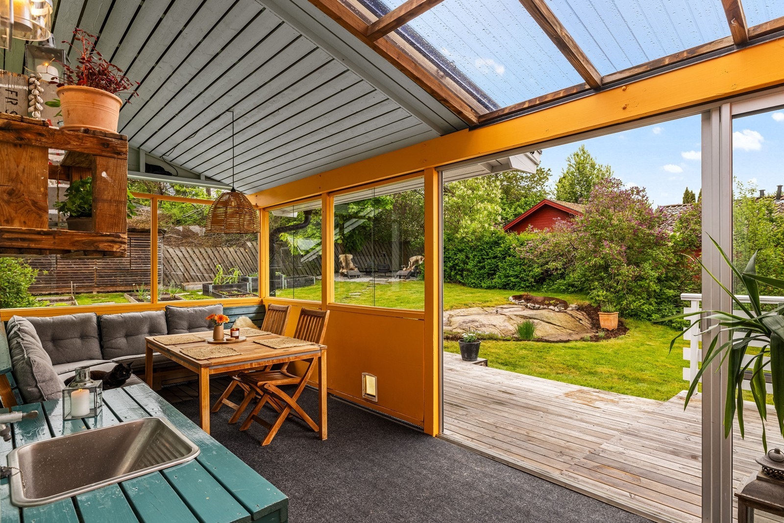 Skyvedører i glass åpner opp mot resten av verandaen og hagen. Galleribilde