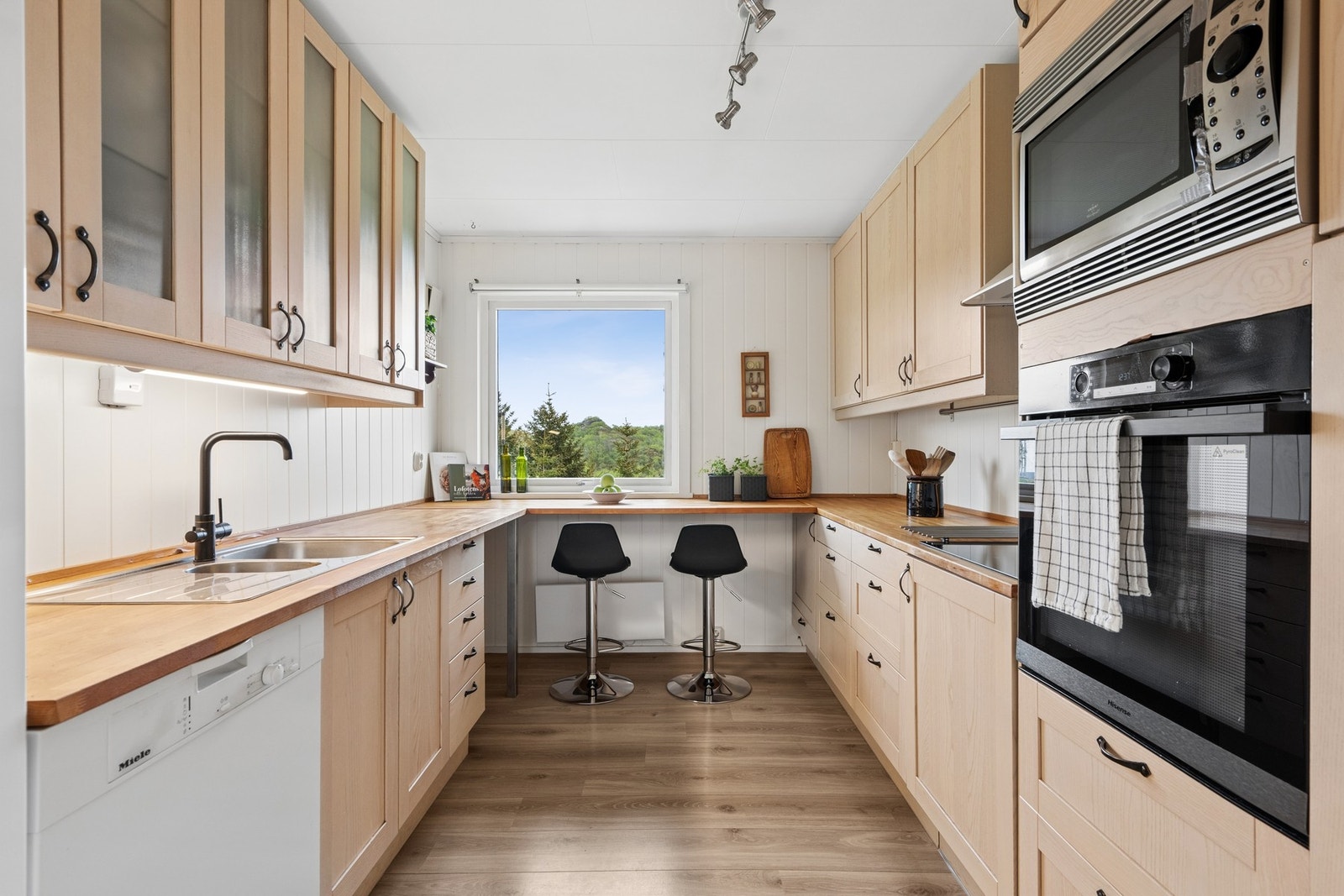 Kjøkkeninnredning fra IKEA med benkeplater i eik, samt integrert stekeovn og mikrobølgeovn. Galleribilde