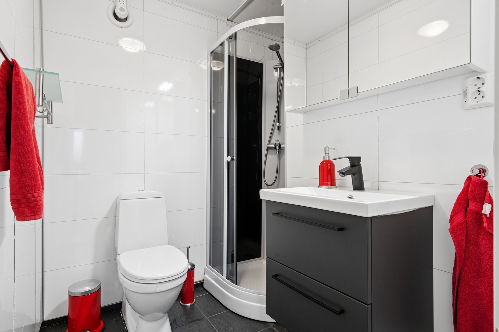 Badet er utstyrt med dusjkabinett, servant med skap og speilskap med belysning. Galleribilde