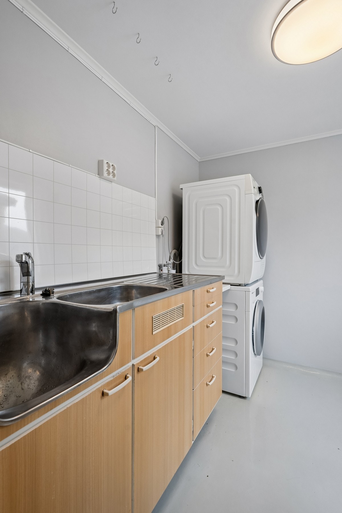 Separat vaskerom med innreiing med skyllekar og oppbevaring. Opplegg for vaskemaskin og tørketrommel. Praktisk nærleik til utgang til hageområdet, med mellomgang med god skapplass Galleribilde