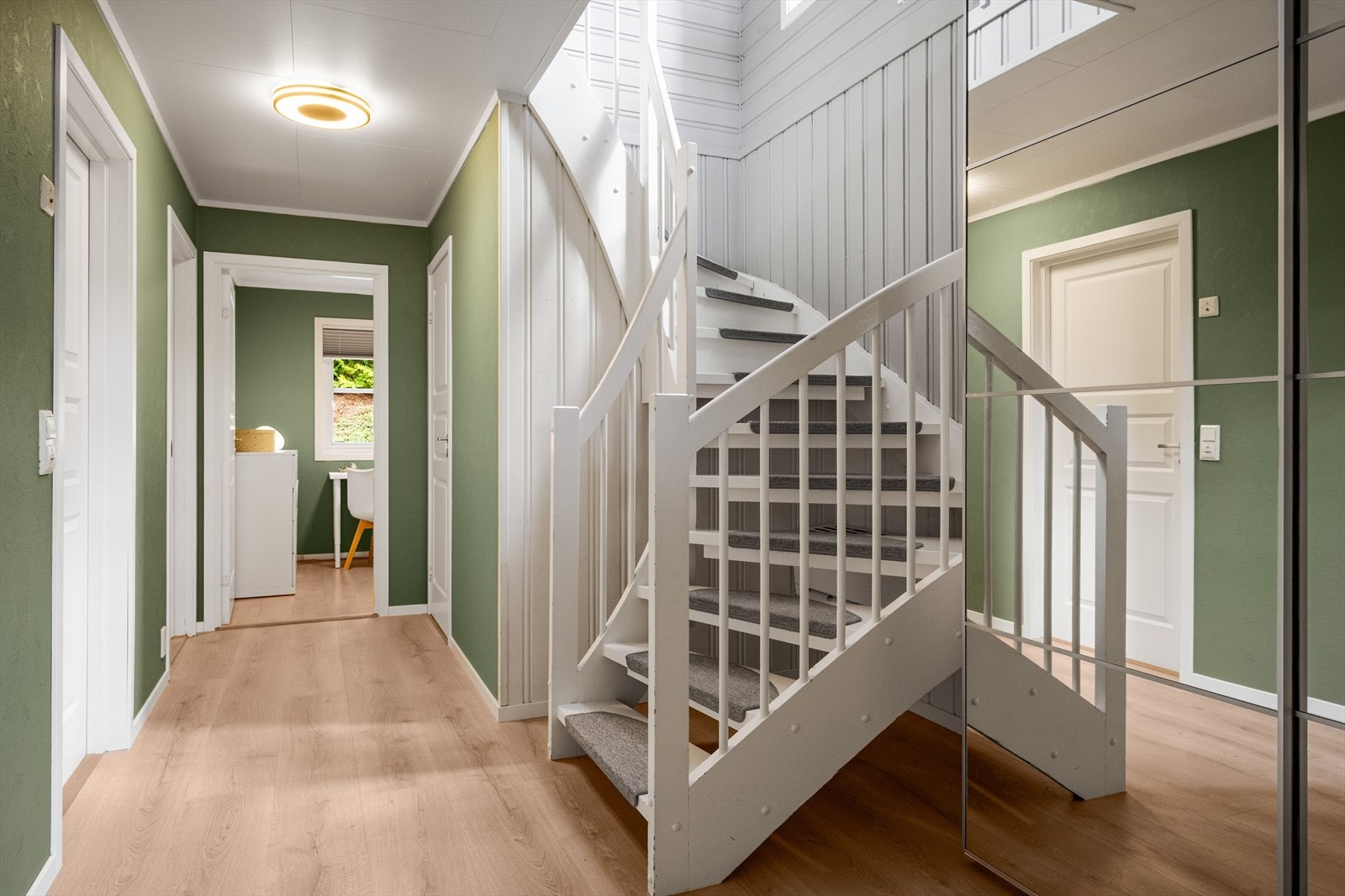 Gang i 1. etasje med adkomst til alle etasjens rom. Det er satt inn en romslig skyvedørsgarderobe med speilfronter. Døra til høyre leder til et lite vaskerom/bod. Galleribilde
