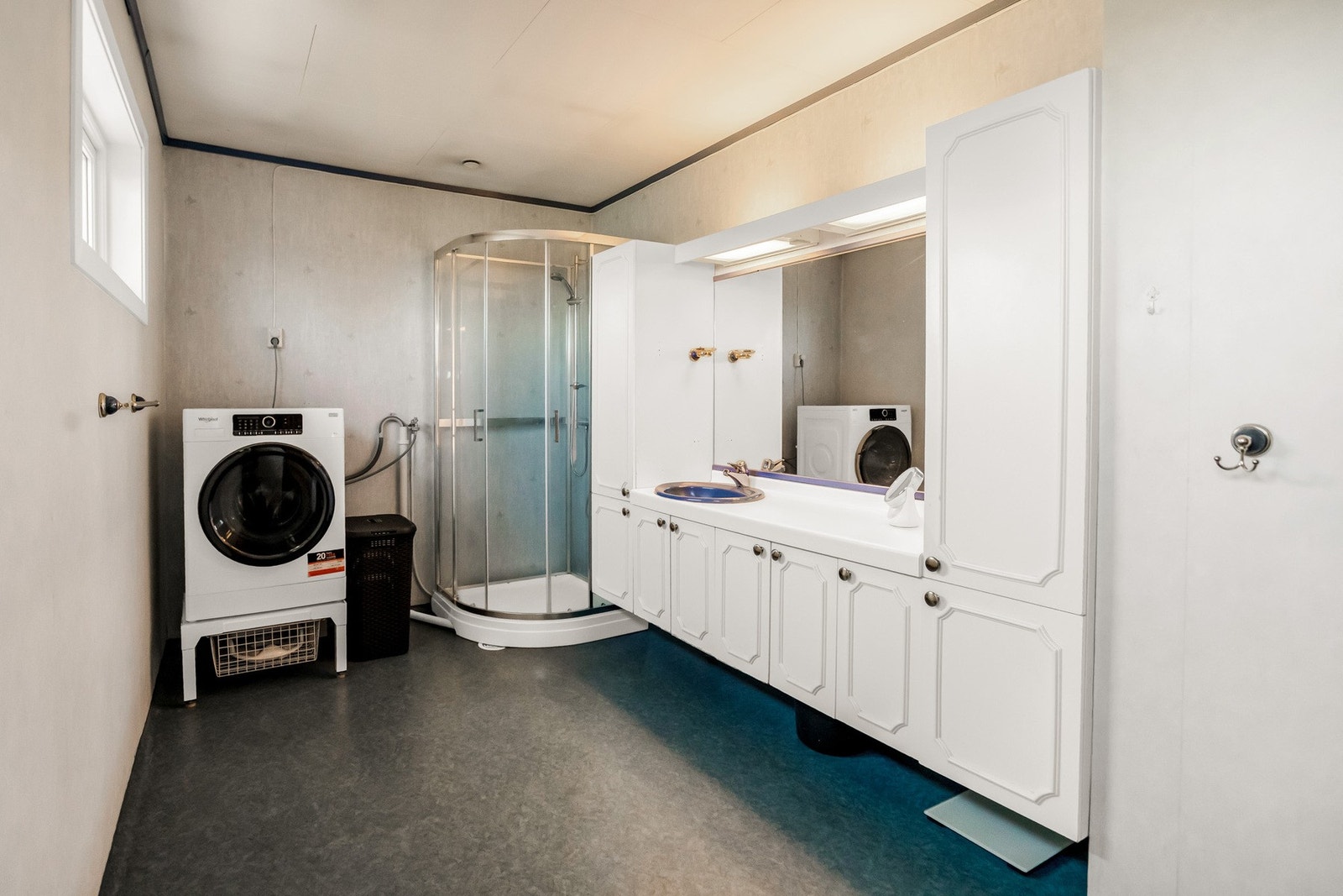 Baderommet er utstyrt med dusjkabinett, nedfelt servant, opplegg for vaskemaskin og toalett. Galleribilde