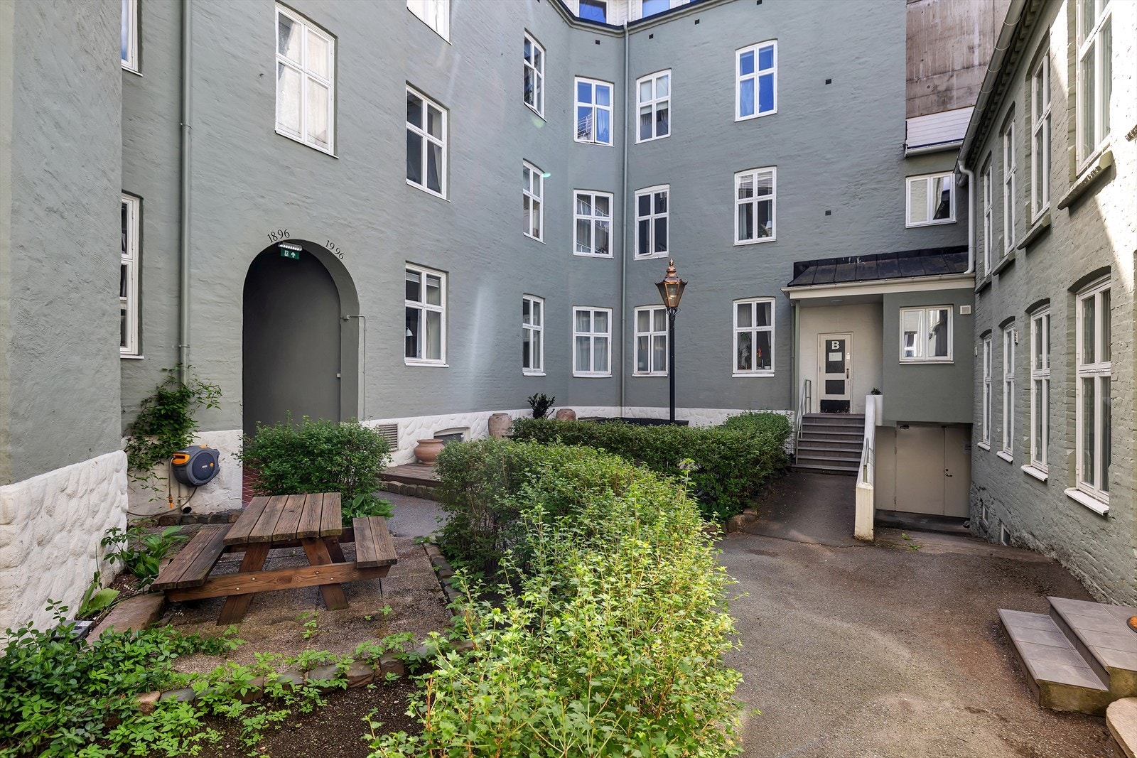 Superhyggelig bakgård med diverse beplantning og sittegrupper. Galleribilde