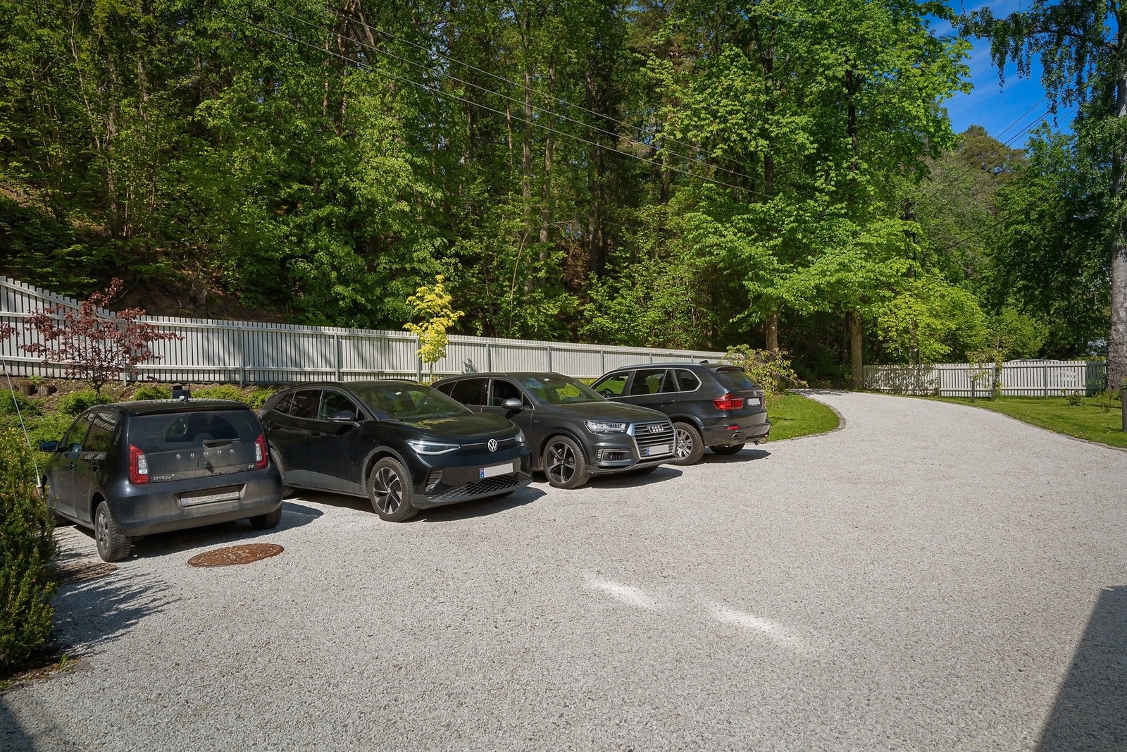 Det medfølger to parkeringsplasser på gruset gårdsplass. Det er montert ladestolpe mellom plassene. Galleribilde