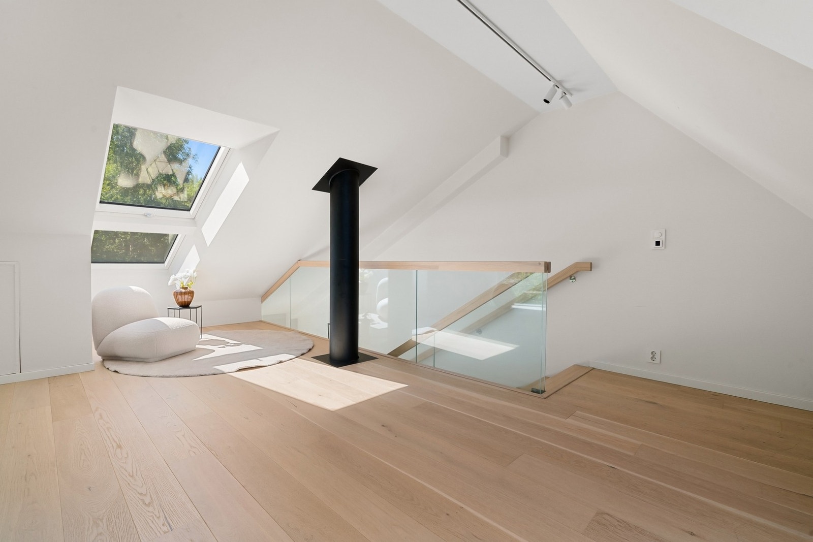 I loftsetasjen ligger en nydelig loftstue med skråhimling, enstavs parkett og lyse overflater. Galleribilde