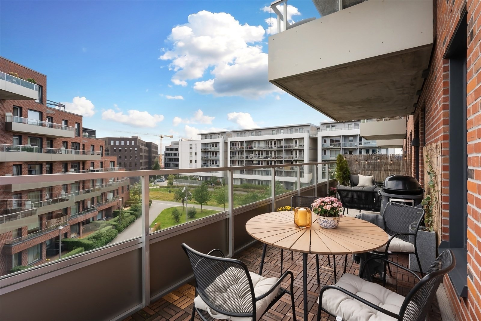 Delvis overbygget balkong med tremmer i tre på dekke, rekkverk i metall og glass. Galleribilde