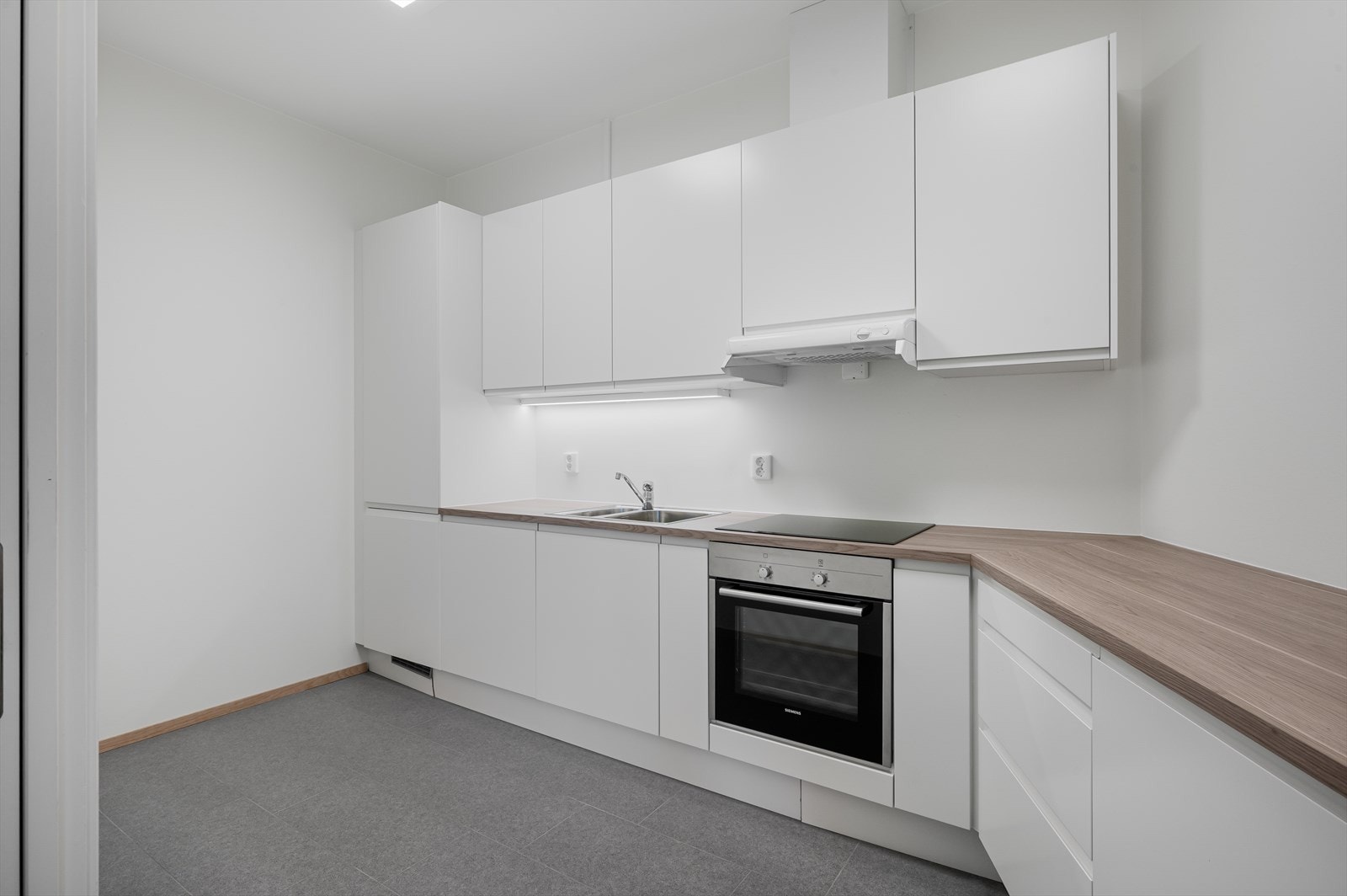 Kjøkkenet er på 8,8 m² og er innredet med Norema kjøkkeninnredning med glatte fronter og integrert gripeprofil. Galleribilde