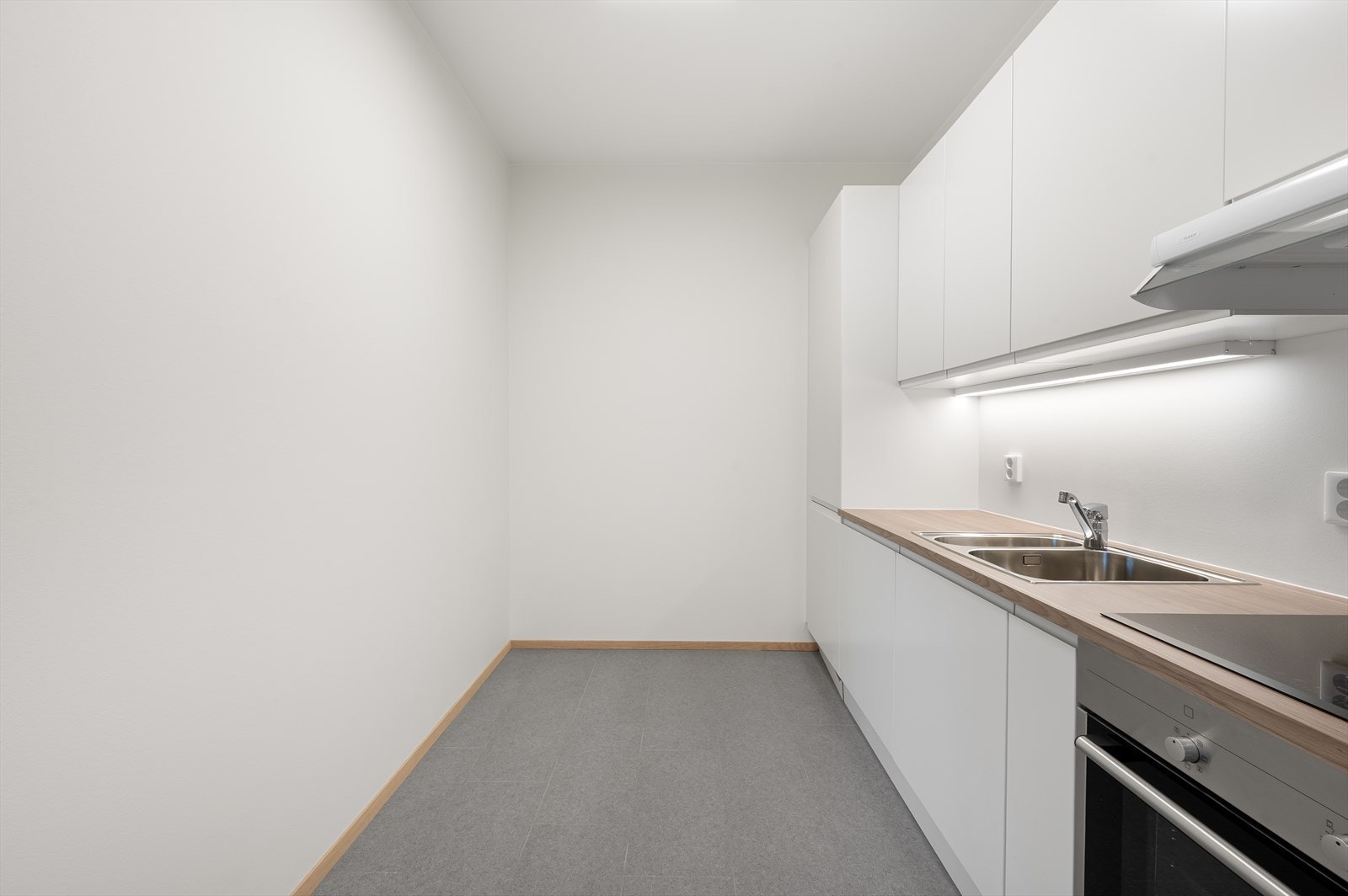 Benkeplaten er i laminat, og kjøkkenet er utstyrt med kjøle-/fryseskap, oppvaskmaskin, platetopp og stekeovn. Galleribilde