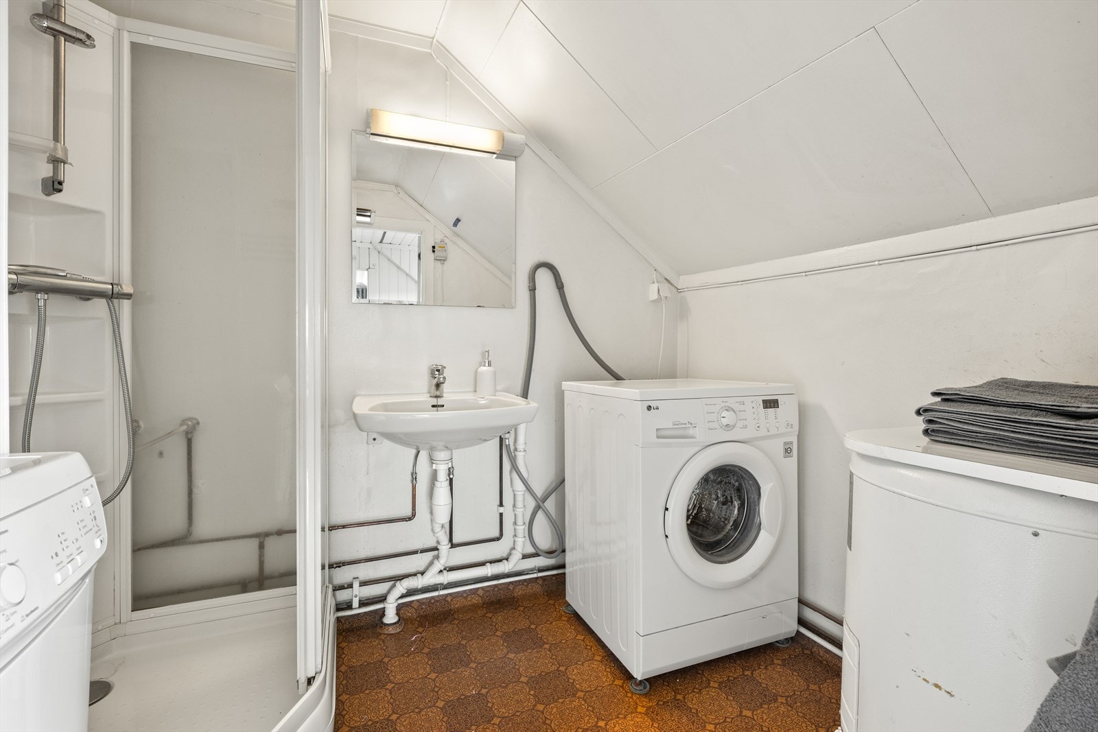 Badet i loftsetasjen er utstyrt med dusjkabinett, servant og har opplegg for vaskemaskin. Galleribilde